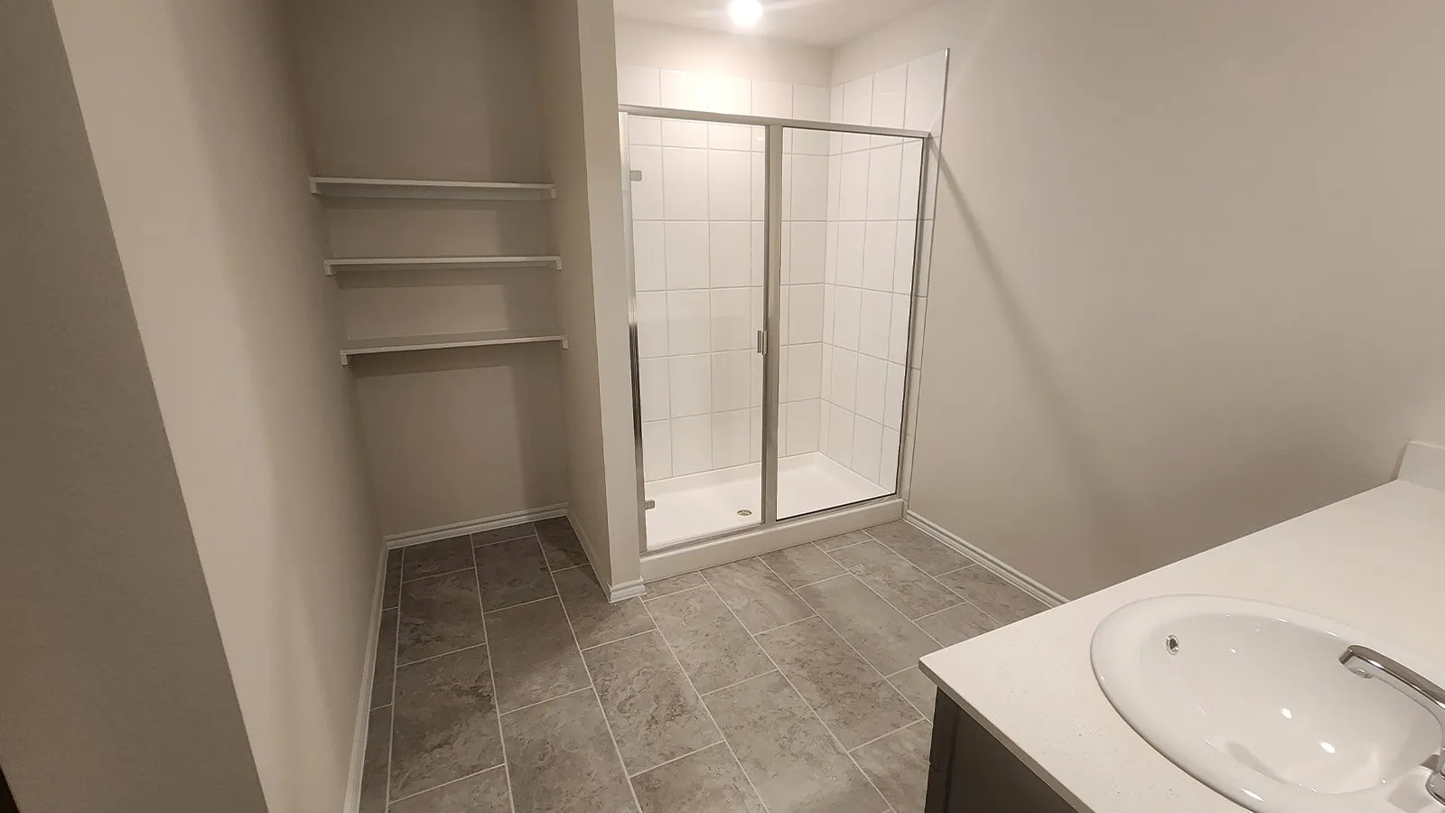 Walk-in shower with clear glass enclosure, tiled walls, and a built-in shower pan