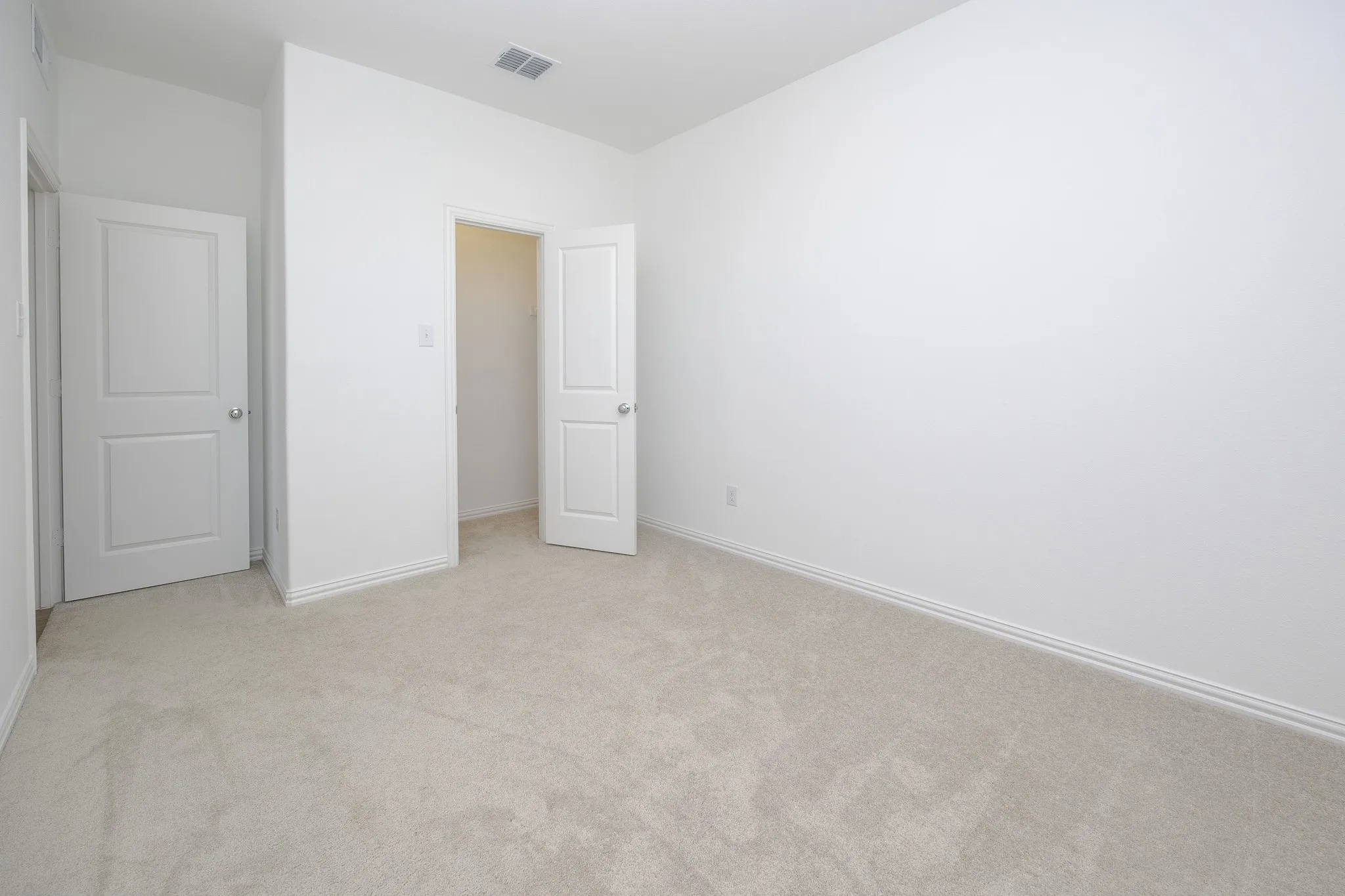Neutral tone carpet flooring and crisp white walls
