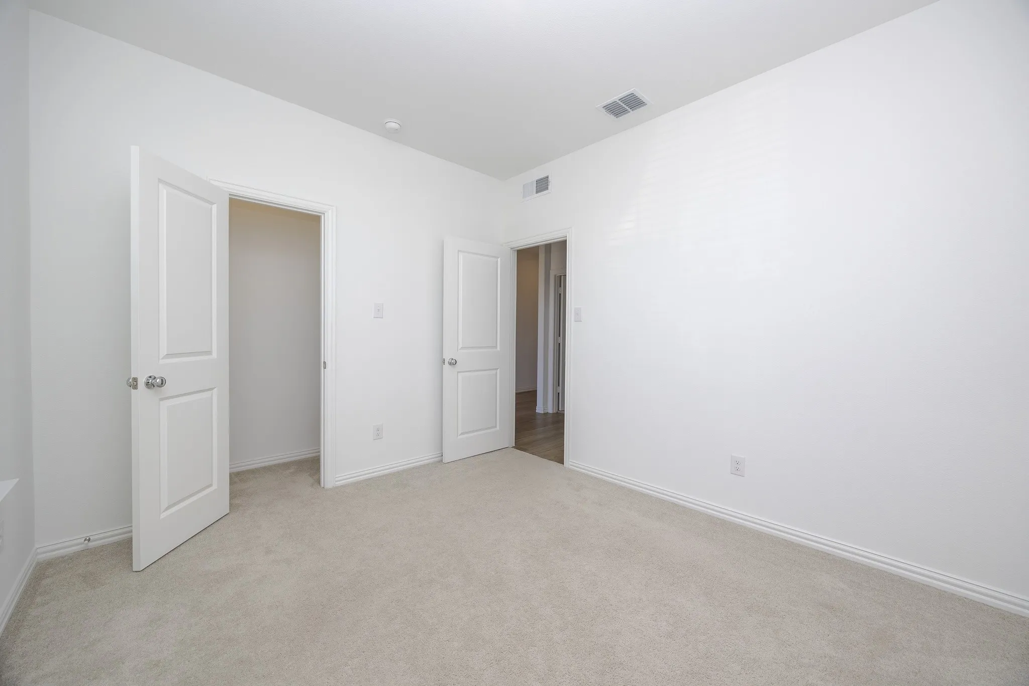 Neutral-toned carpeting, white walls, and white trim