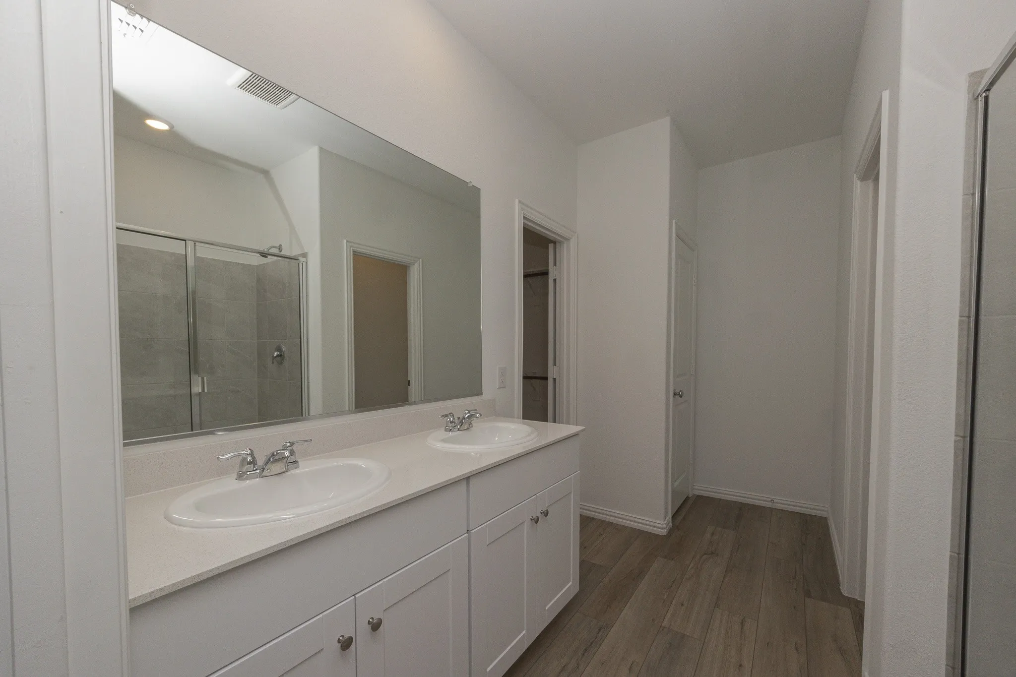 Dual vanity with white cabinetry, a light-toned countertop, and undermount sinks