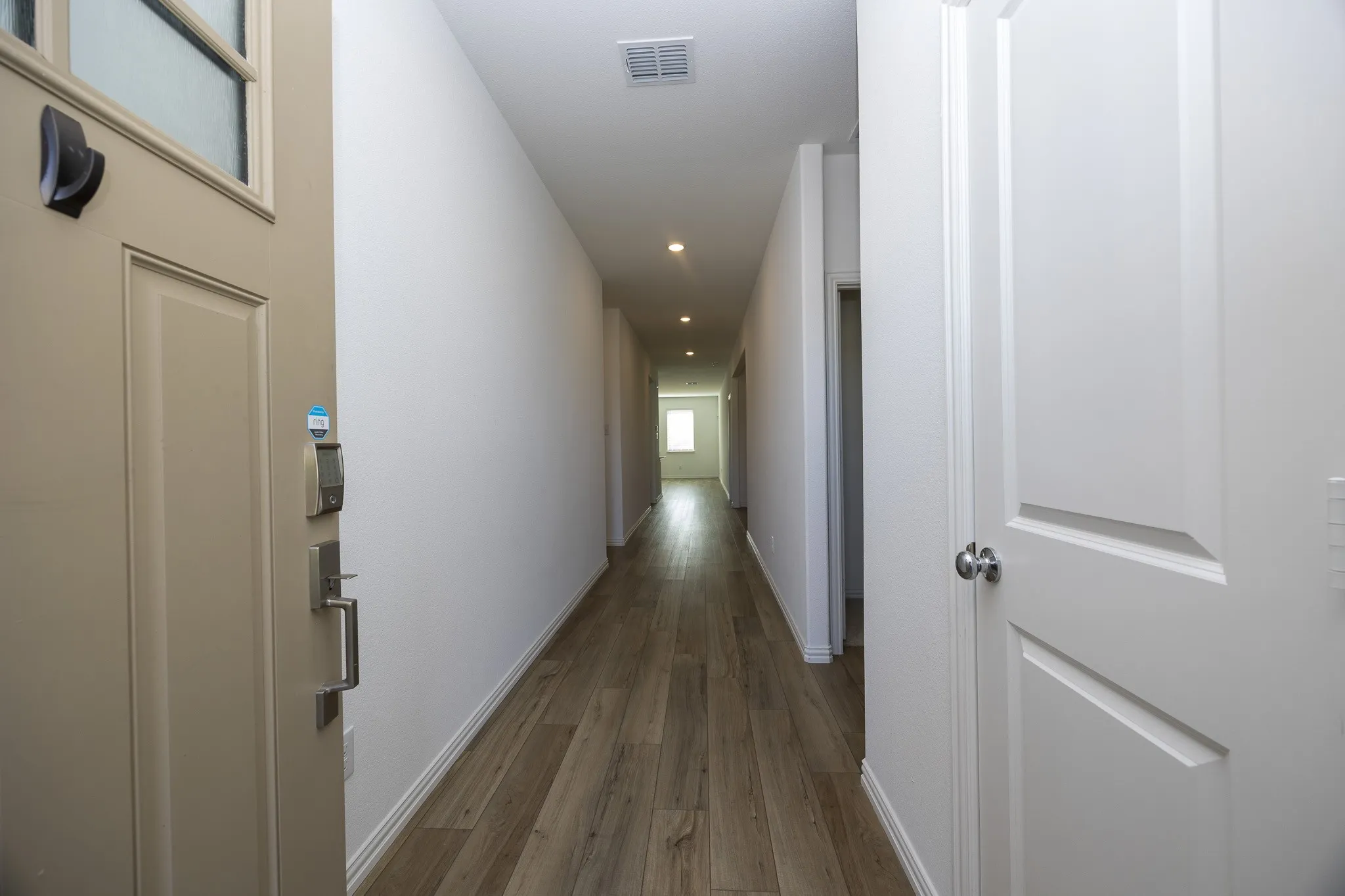 Recessed lighting illuminates wood-finish flooring