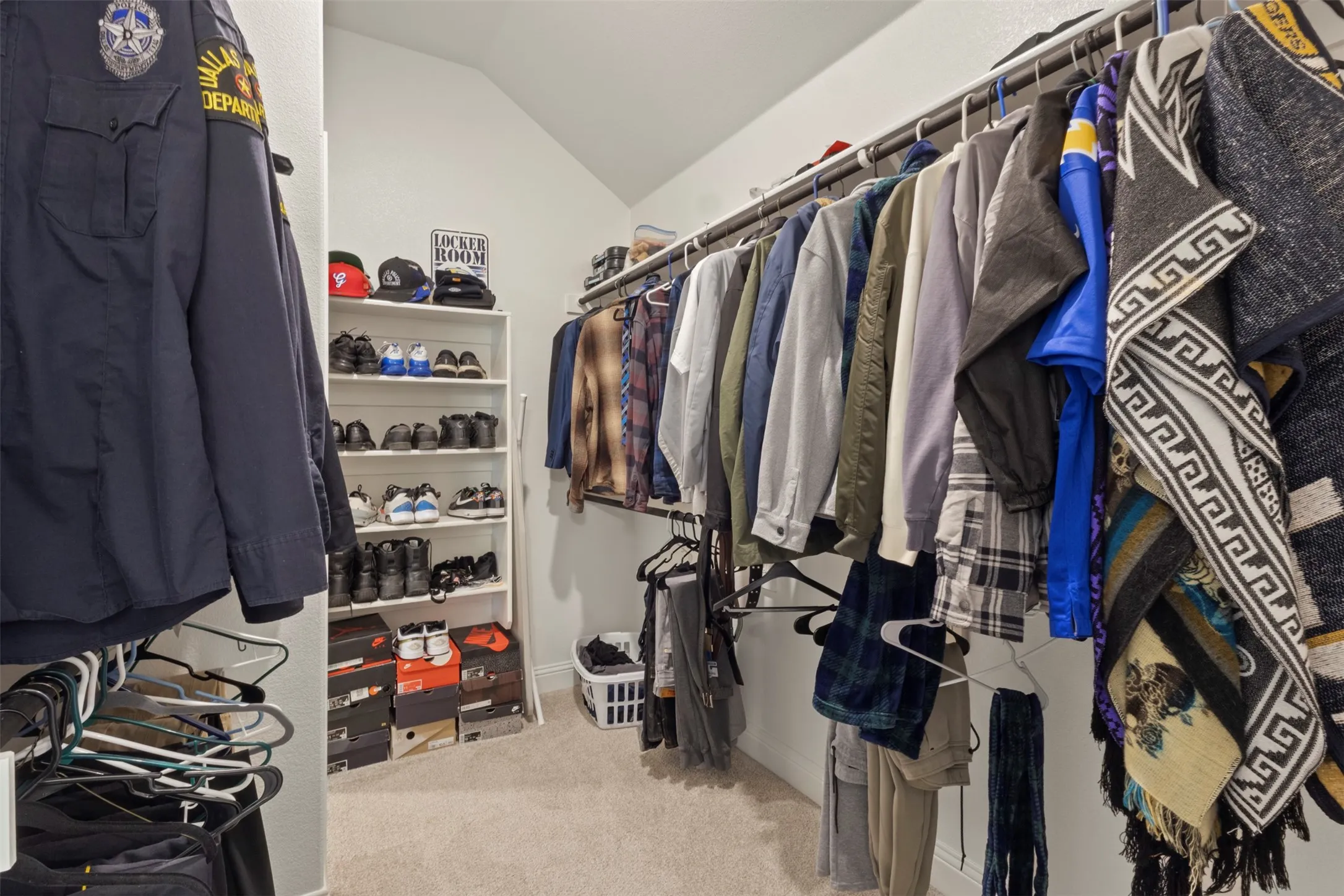 Walk-in closet with sloped ceiling, carpet flooring, and custom shelving