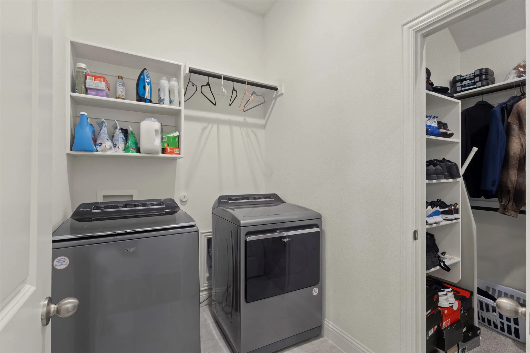 Dedicated laundry area with wall-mounted shelving and a clothing rod