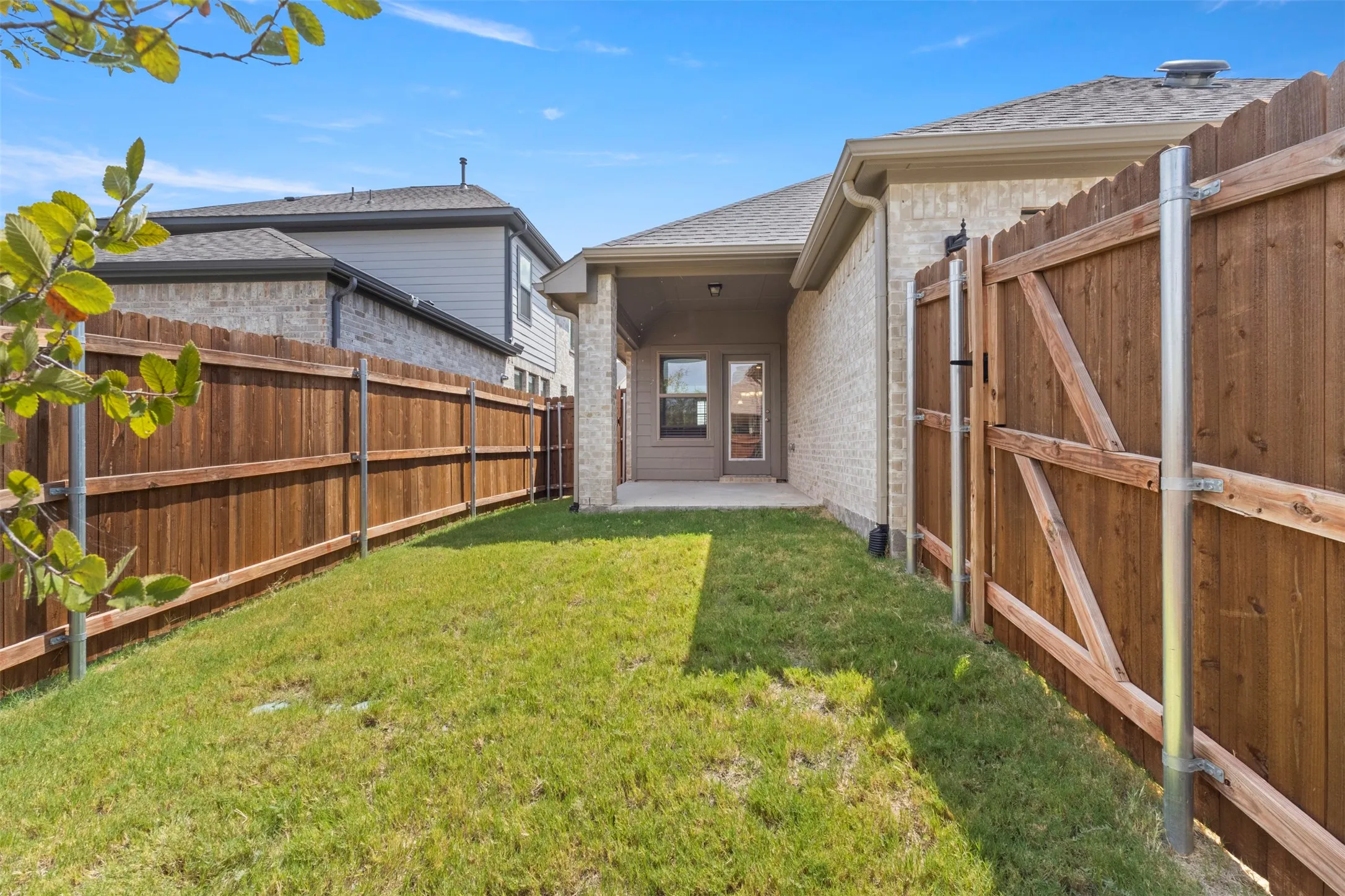 Expansive fenced backyard with a covered patio and a privacy fence