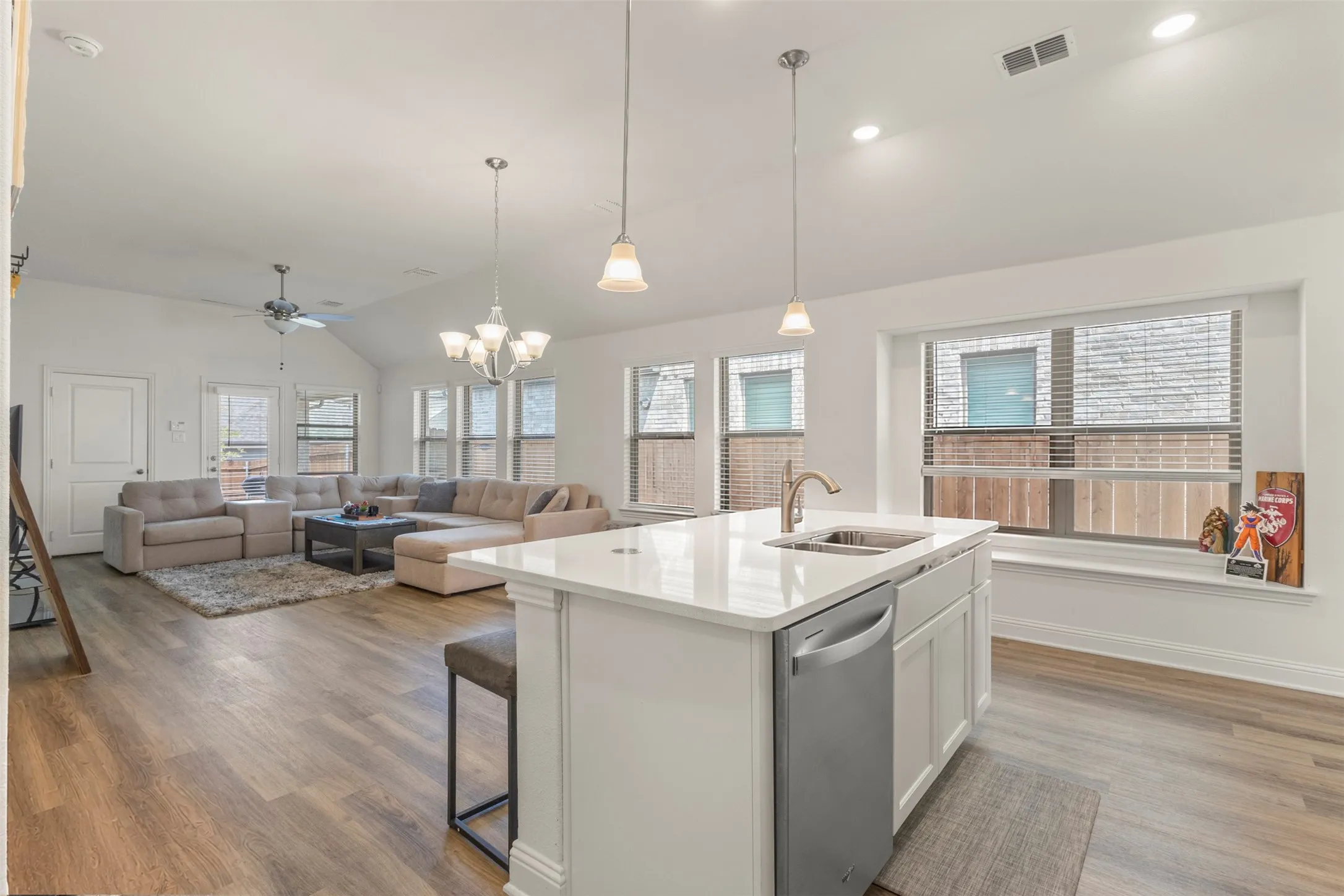 Kitchen island with a built-in stainless steel dishwasher, undermount sink, and polished faucet