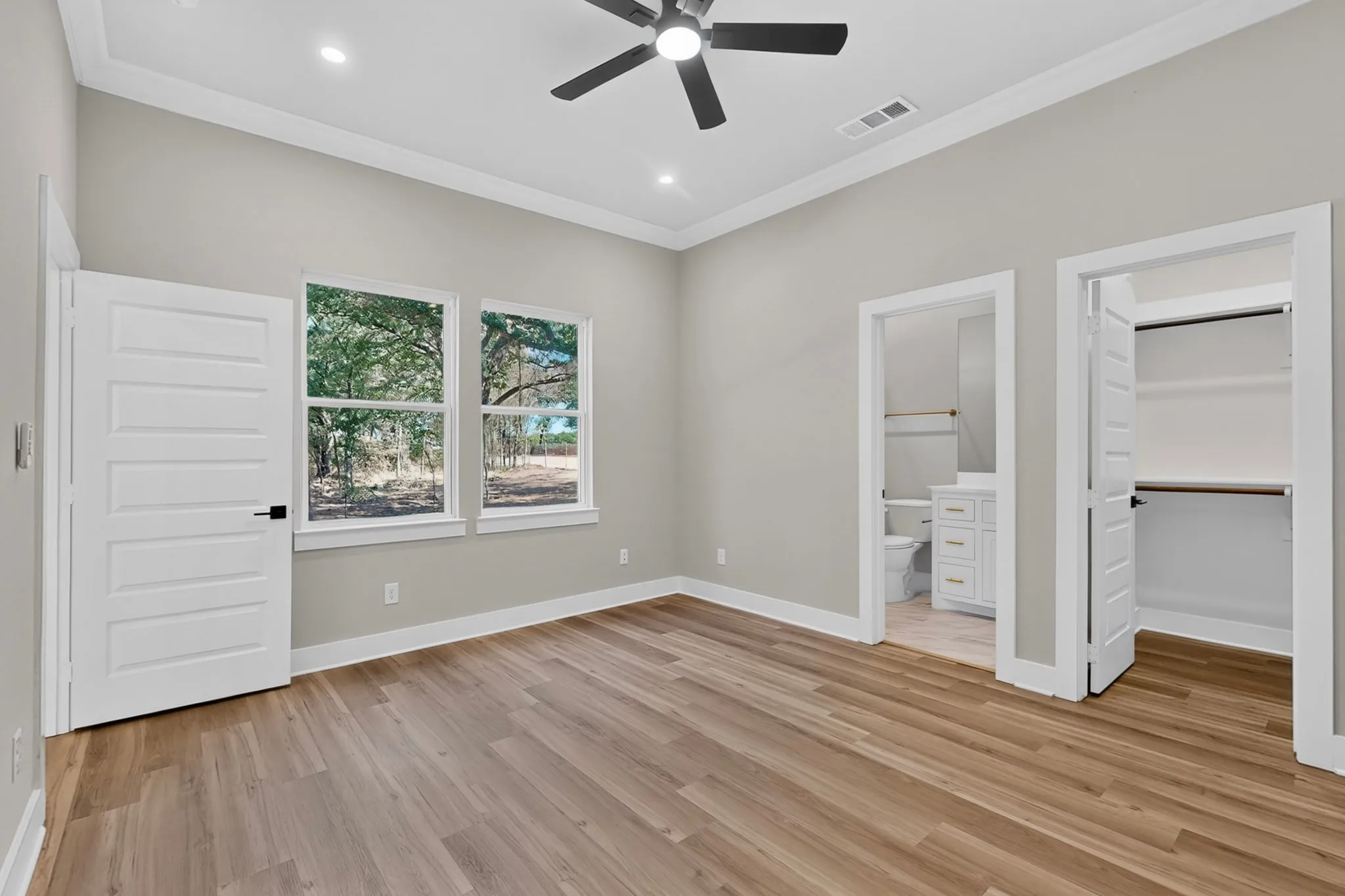Wood-finish flooring with white trim and grey walls