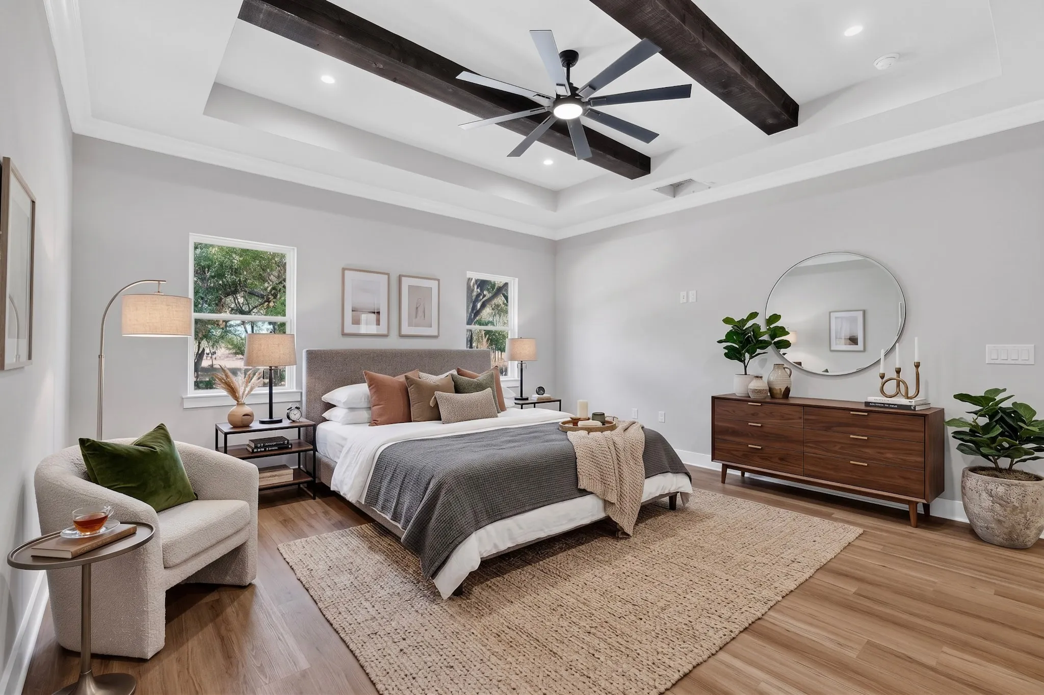 Tray ceiling featuring dark wood-finish beams and a ceiling fan