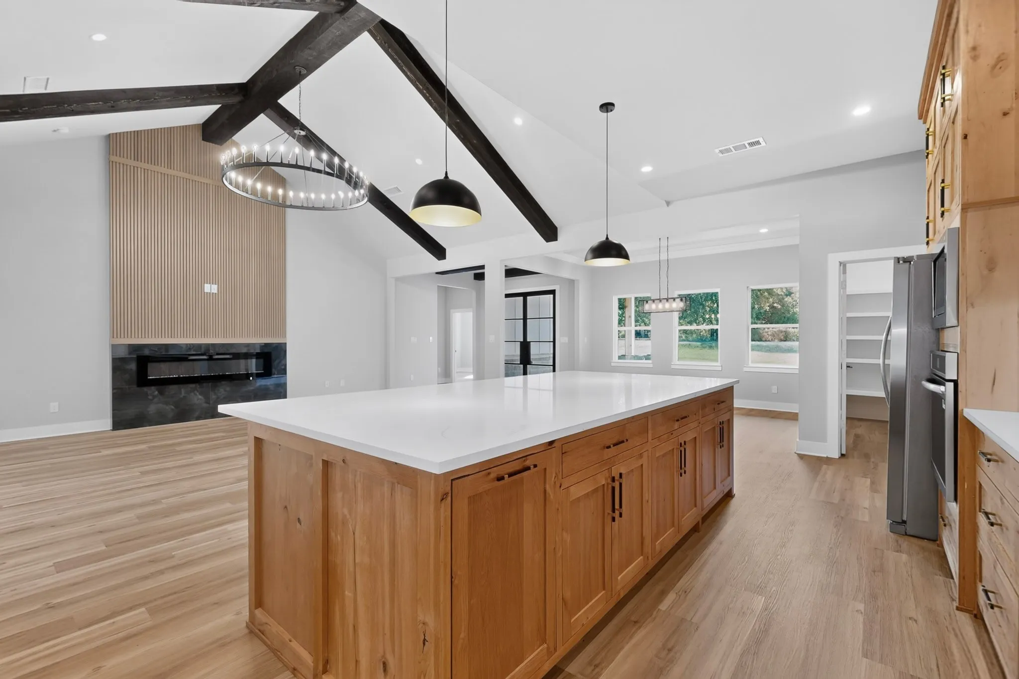 Kitchen island with white countertop, recessed lighting, and wood-finish flooring