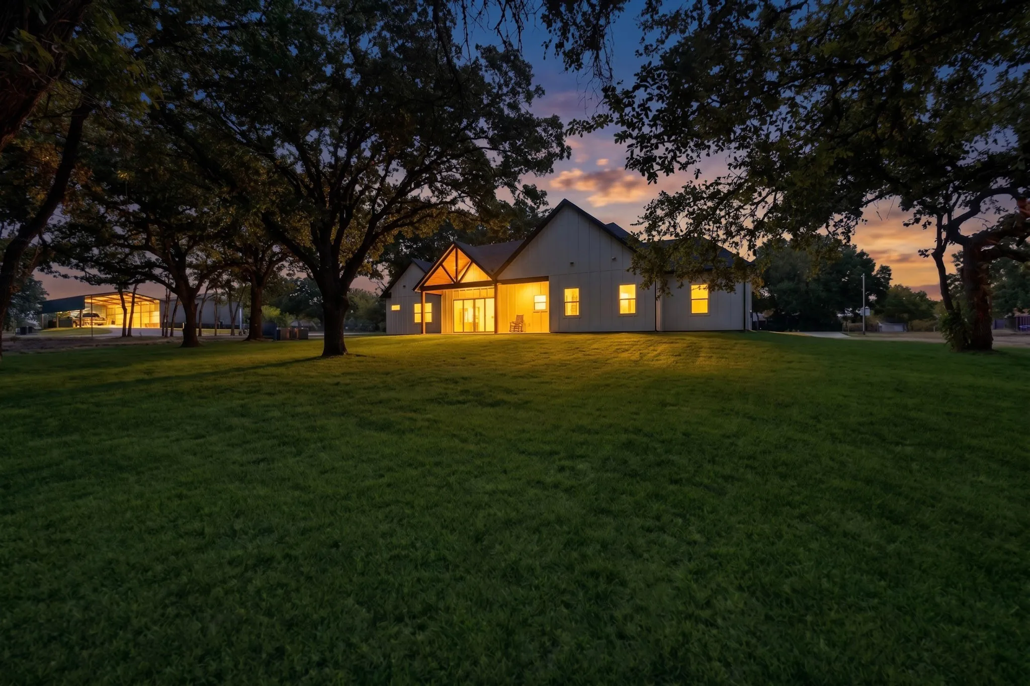 Expansive lawn with mature trees, a gable roofline, and architectural wood-tone accenting on the front facade