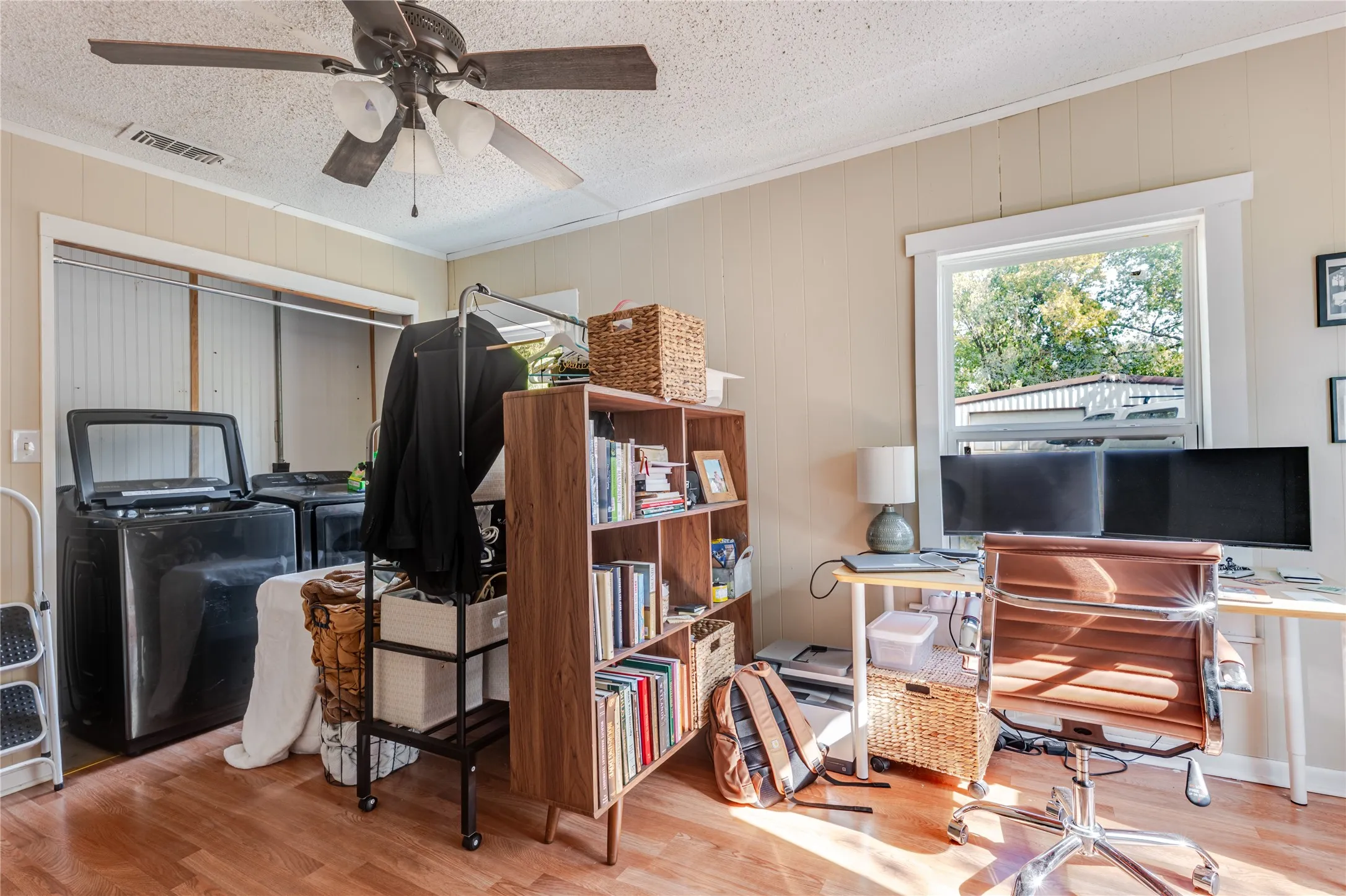 Wood-finish flooring, ceiling fan, and a window with natural light