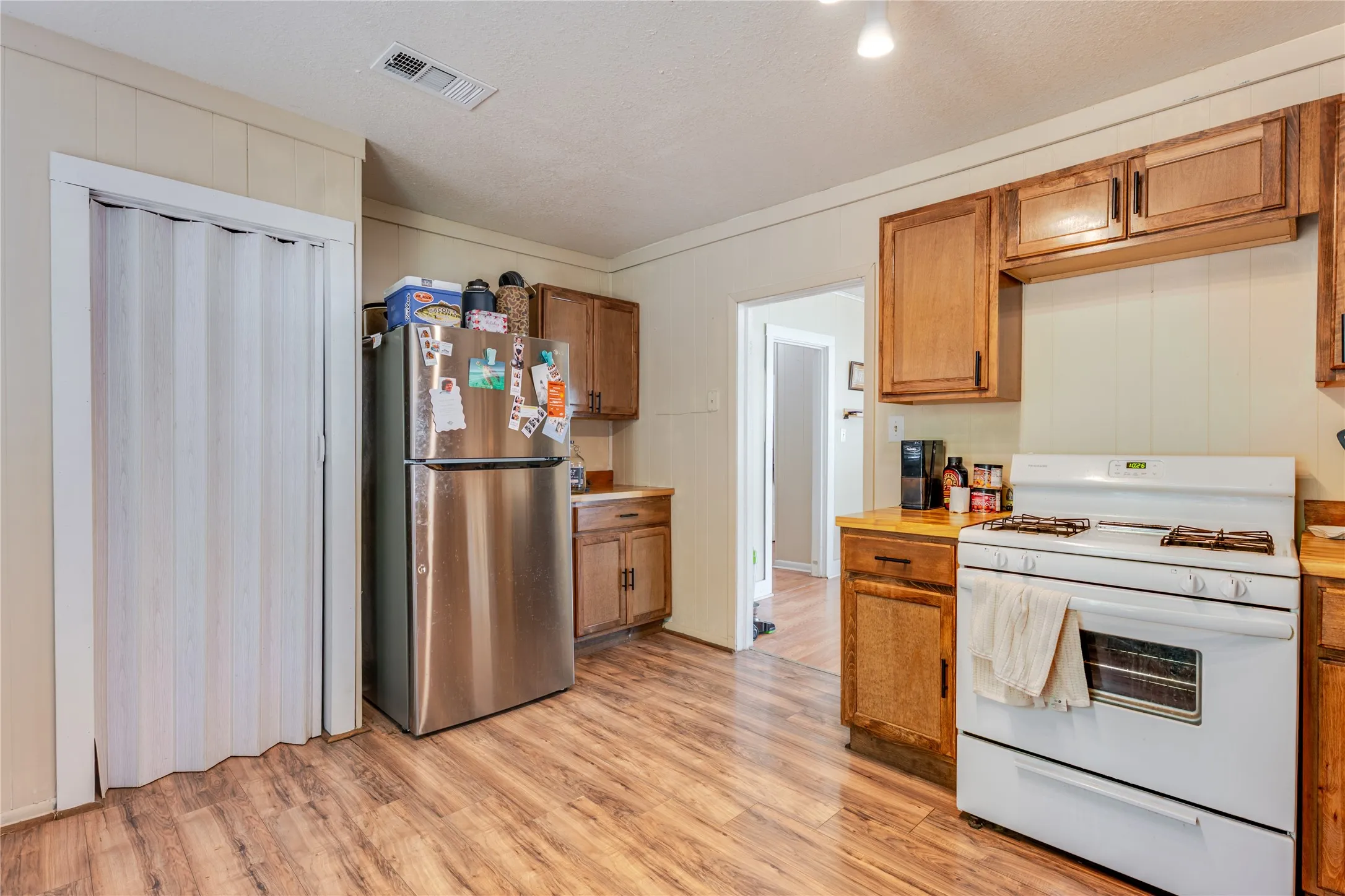 Wood-finish flooring, wood cabinetry, and a white gas range