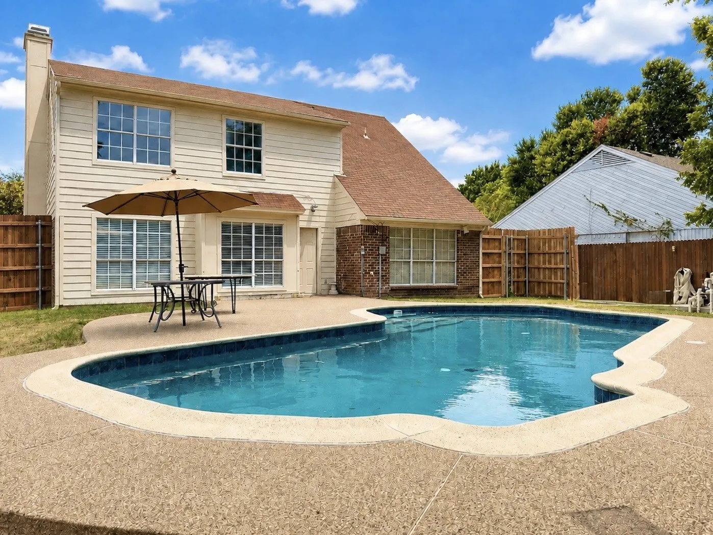 In-ground swimming pool with a surrounding textured concrete deck