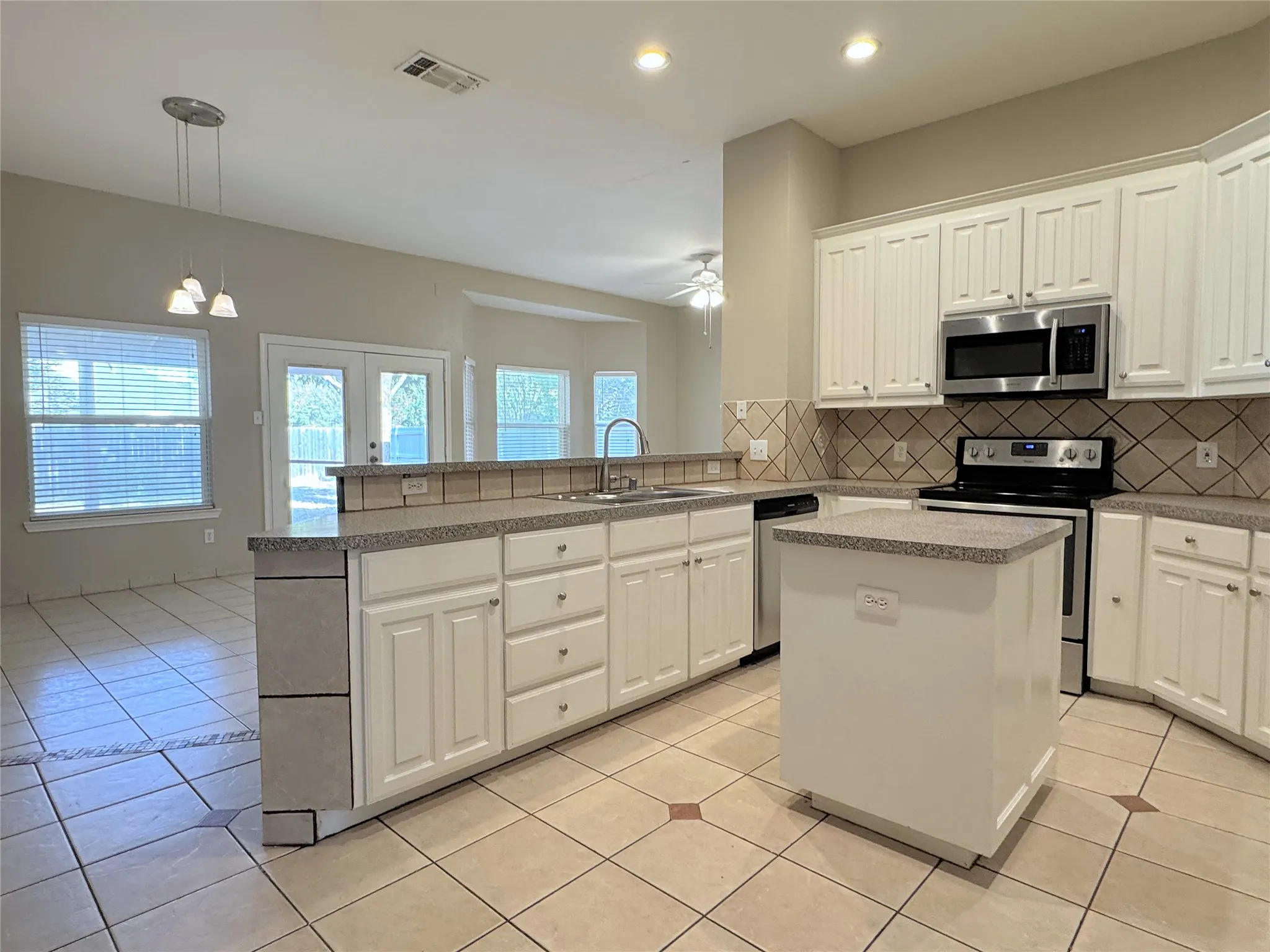 Kitchen opens to the den area overlooking the backyard