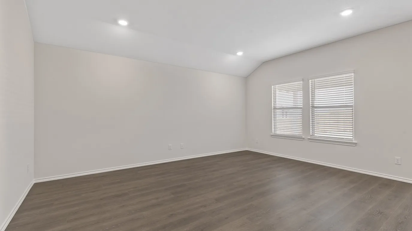 Vaulted ceiling with recessed lighting, wood-finish flooring, and dual windows with blinds