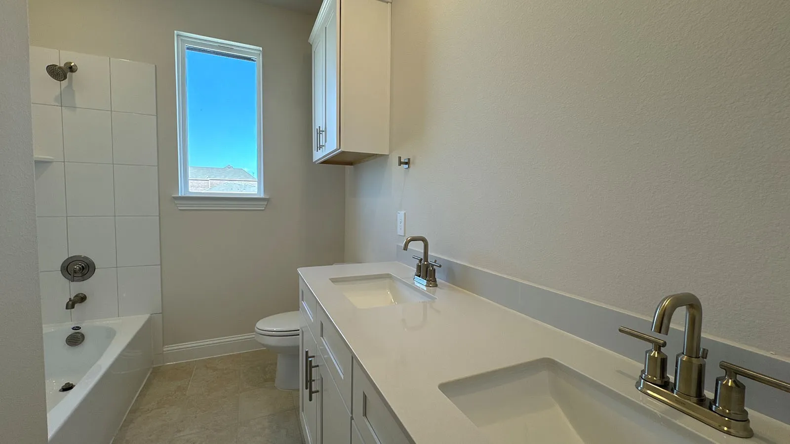 Dual sink vanity with white countertop, white cabinetry, and brushed nickel fixtures