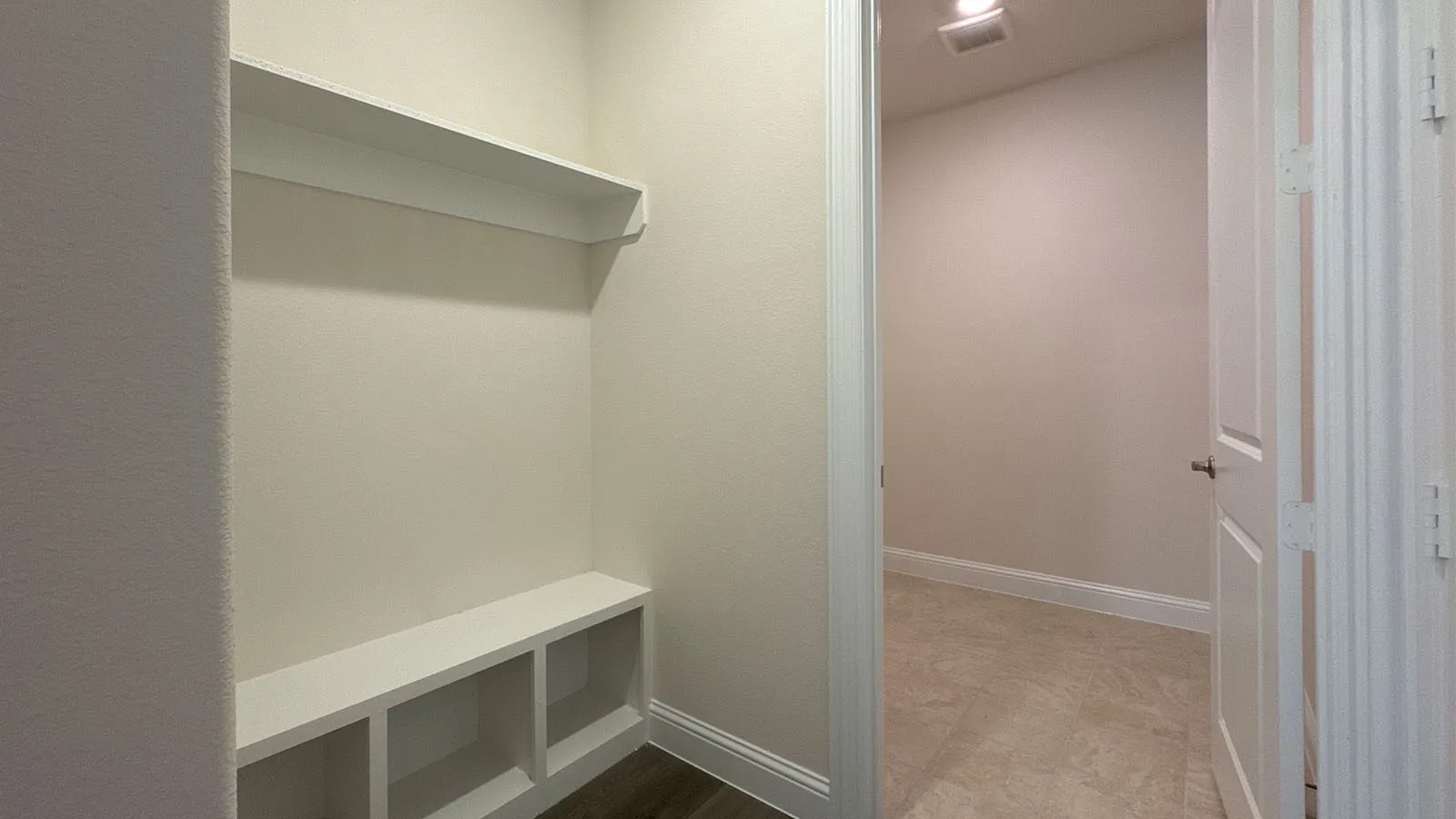 Built-in bench with integrated shelving, overhead shelf, wood-finish flooring, and panel doors