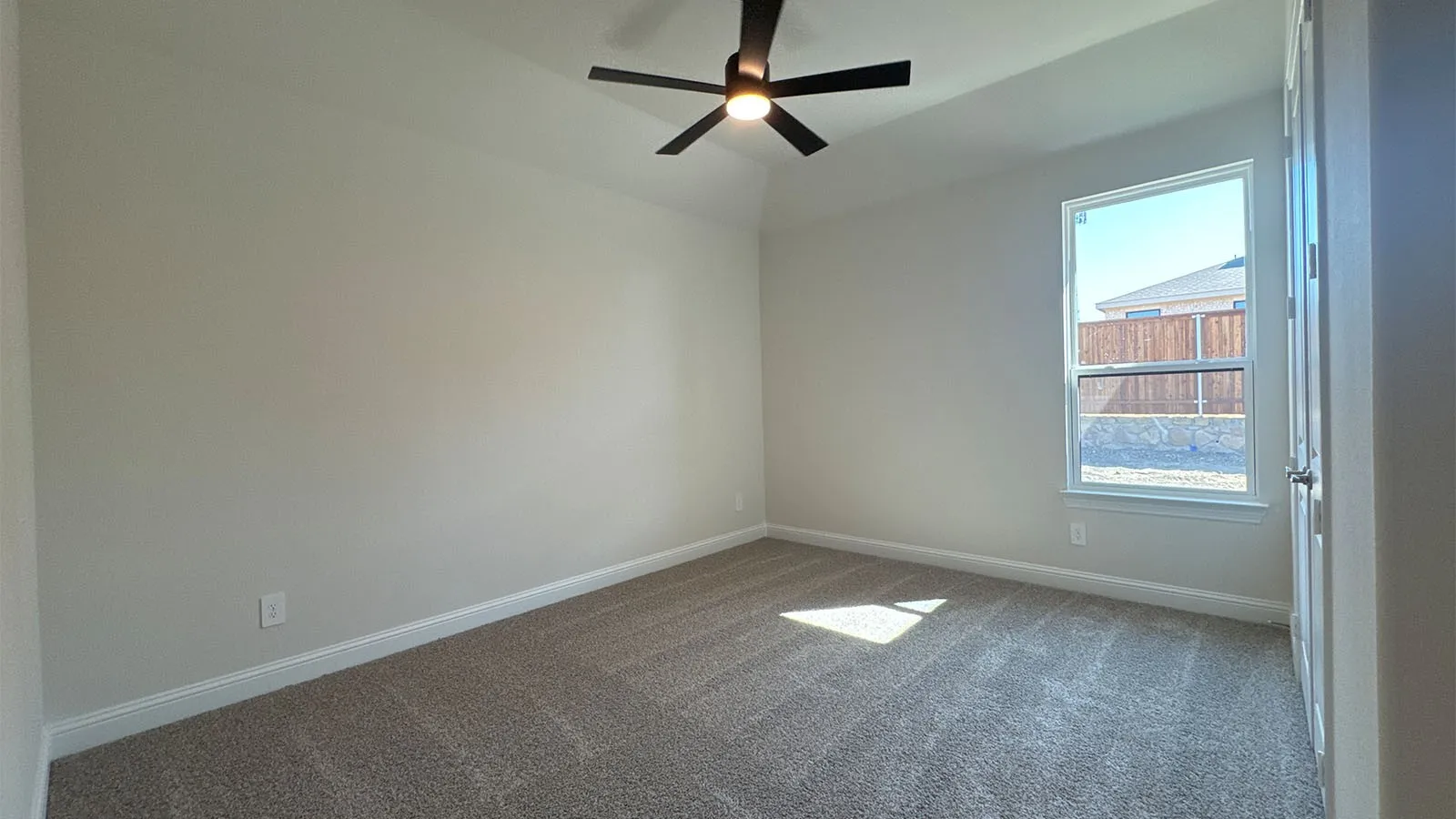 Neutral-toned walls complement the textured gray carpeting