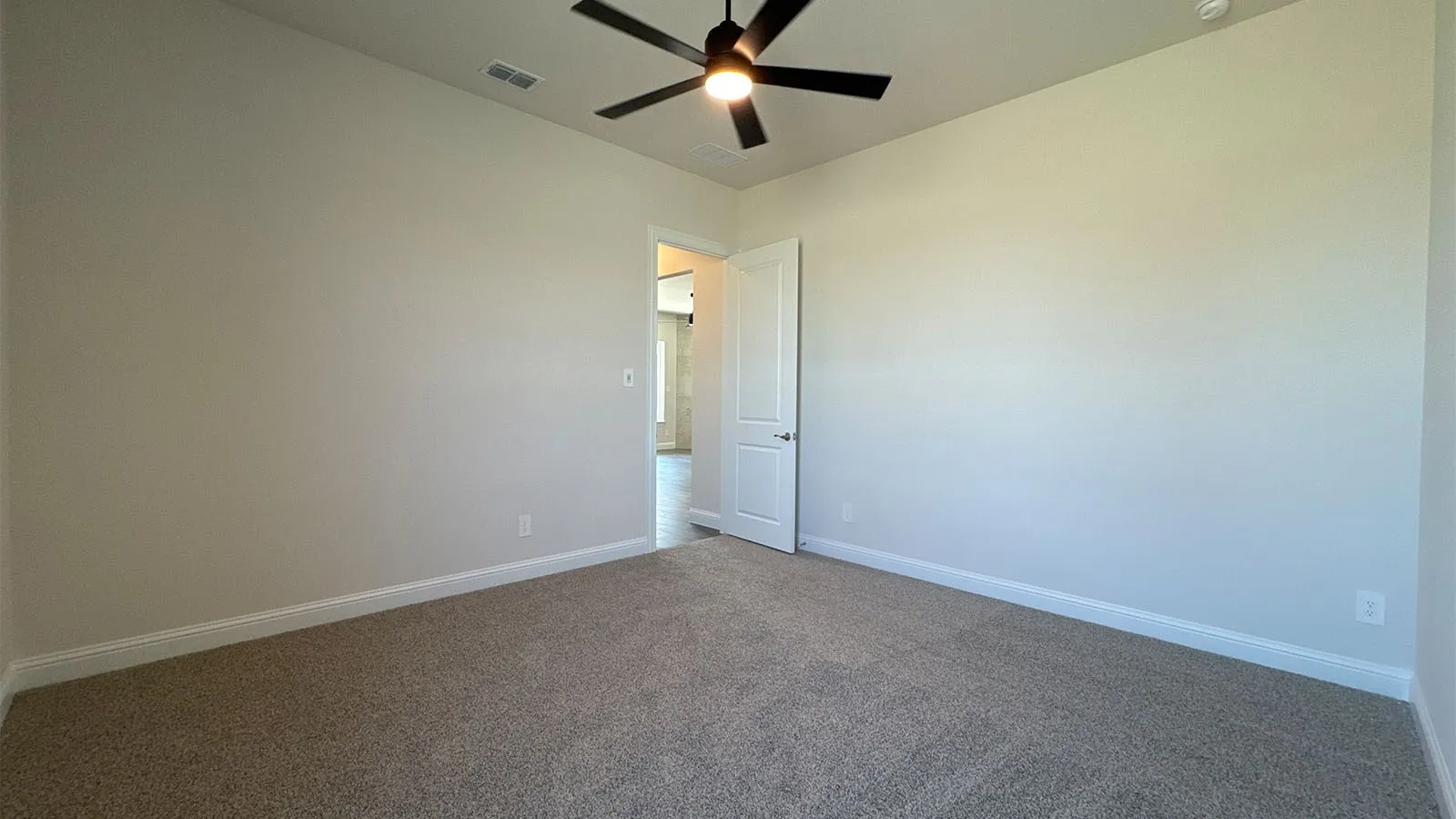 Carpet flooring, neutral wall tones, ceiling fan with integrated lighting, and a white paneled door
