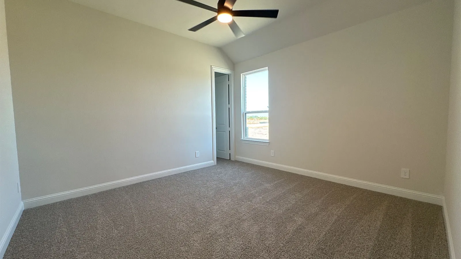 Carpeted flooring with light-toned walls, a single window, and a ceiling fan with light fixture