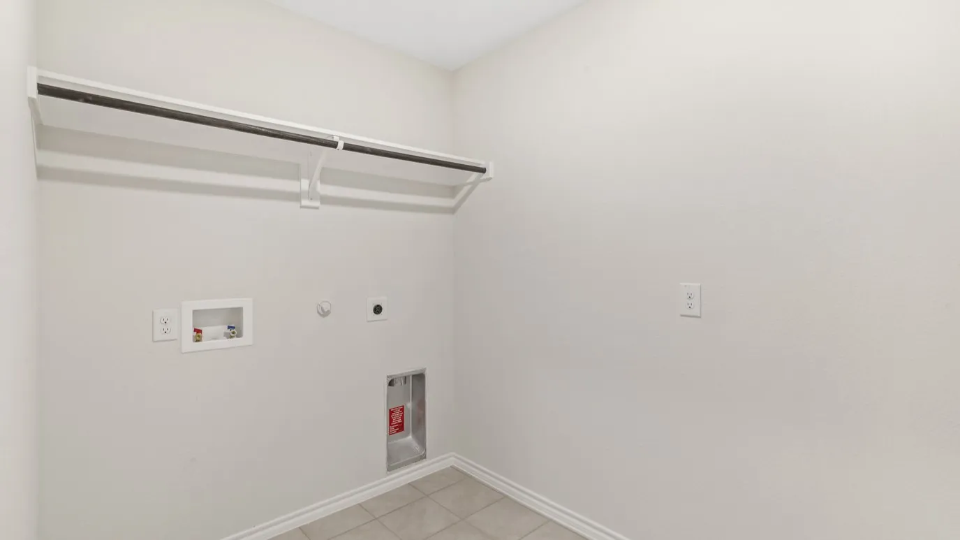 Laundry area with tile flooring and a built-in hanging rod