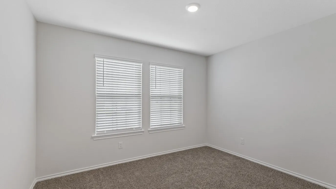 Recessed lighting illuminating neutral wall tones and a plush carpet