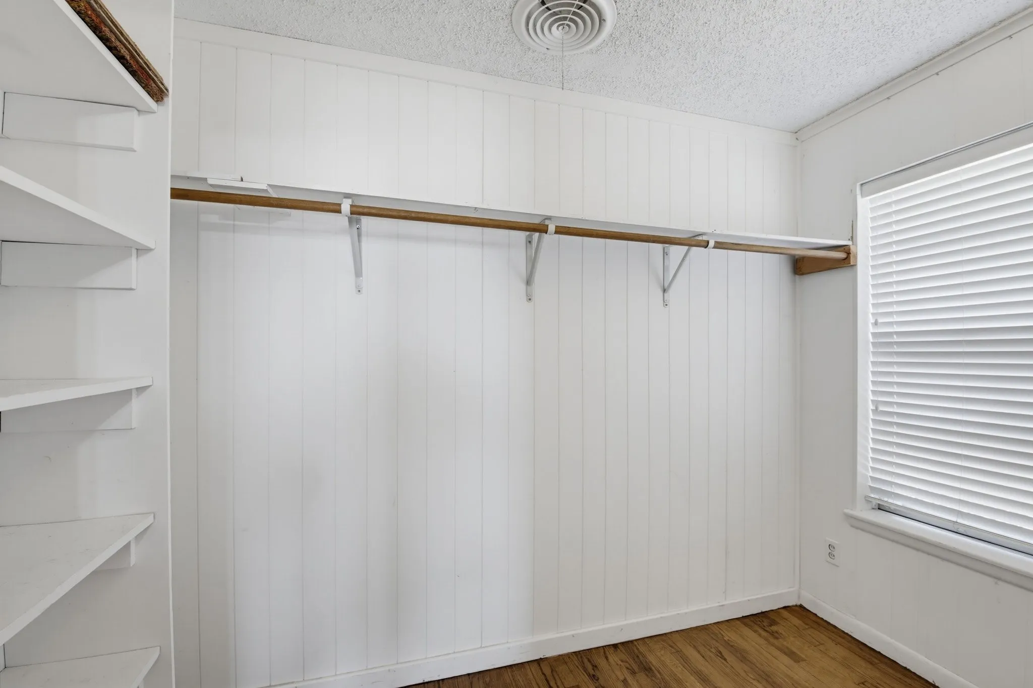 Bedroom 1 with spacious walk-in closet with natural light from the window