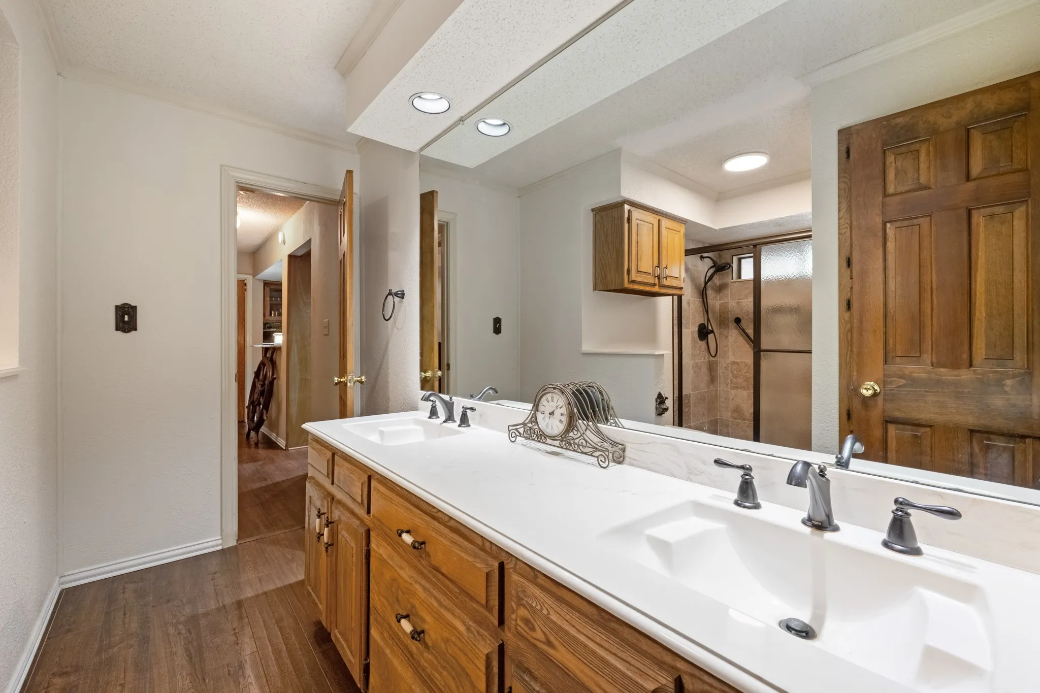 Wood-finish flooring with a dual vanity featuring wood cabinetry