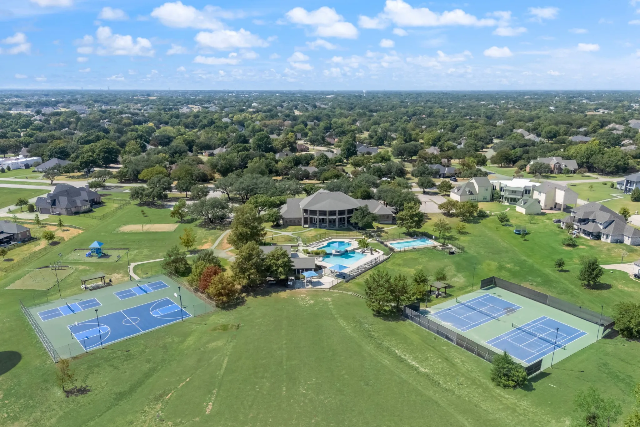 Community amenities featuring two swimming pools, basketball court, two tennis courts, and a playground structure