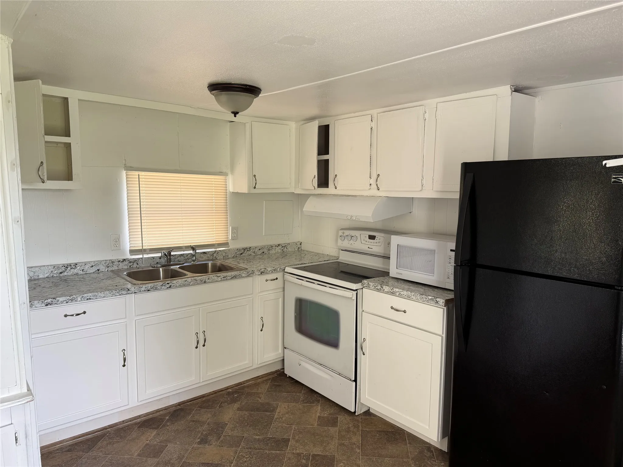 Kitchen with refrigerator, oven, stove, and microwave