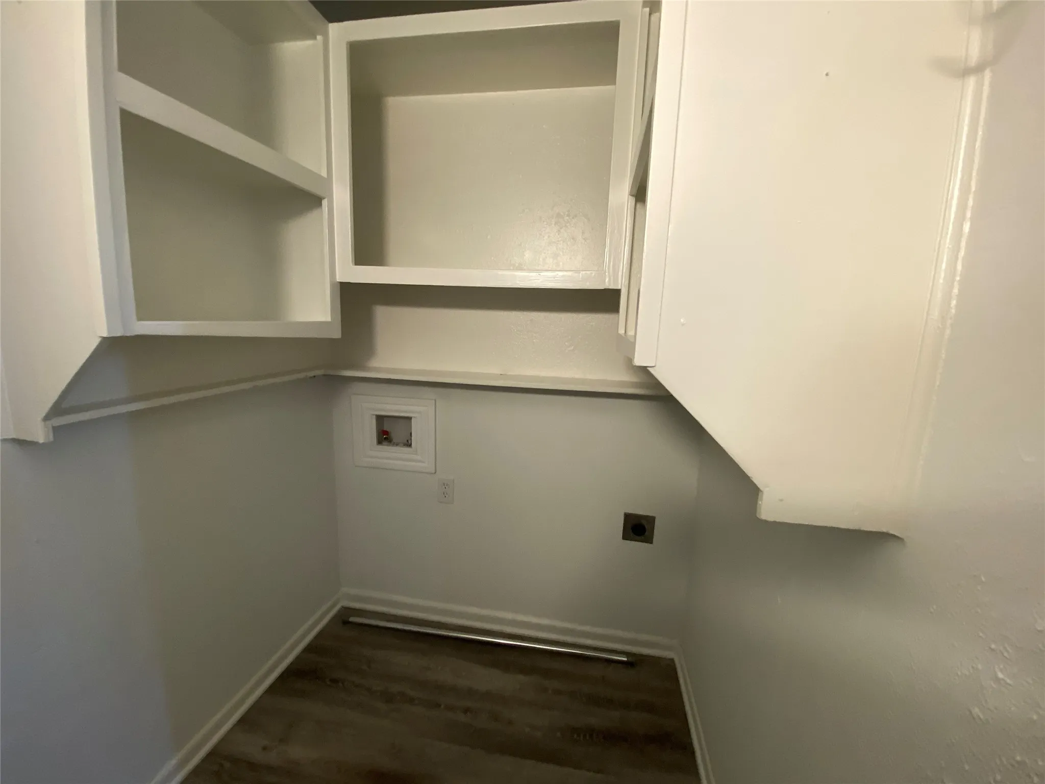 White upper cabinetry, wood-finish flooring, and white walls