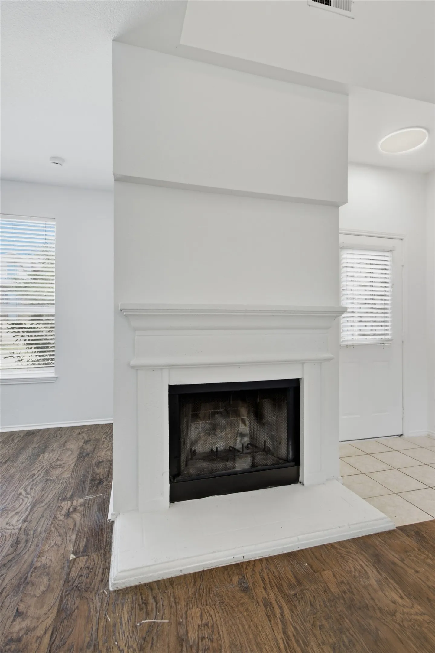 Fireplace featuring a white mantel, hearth, and dark firebox