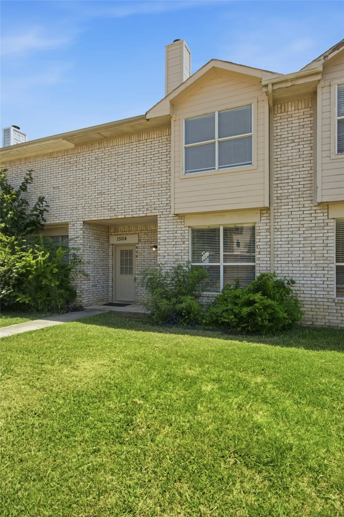 Multi-story exterior featuring light-colored brick and horizontal siding accents