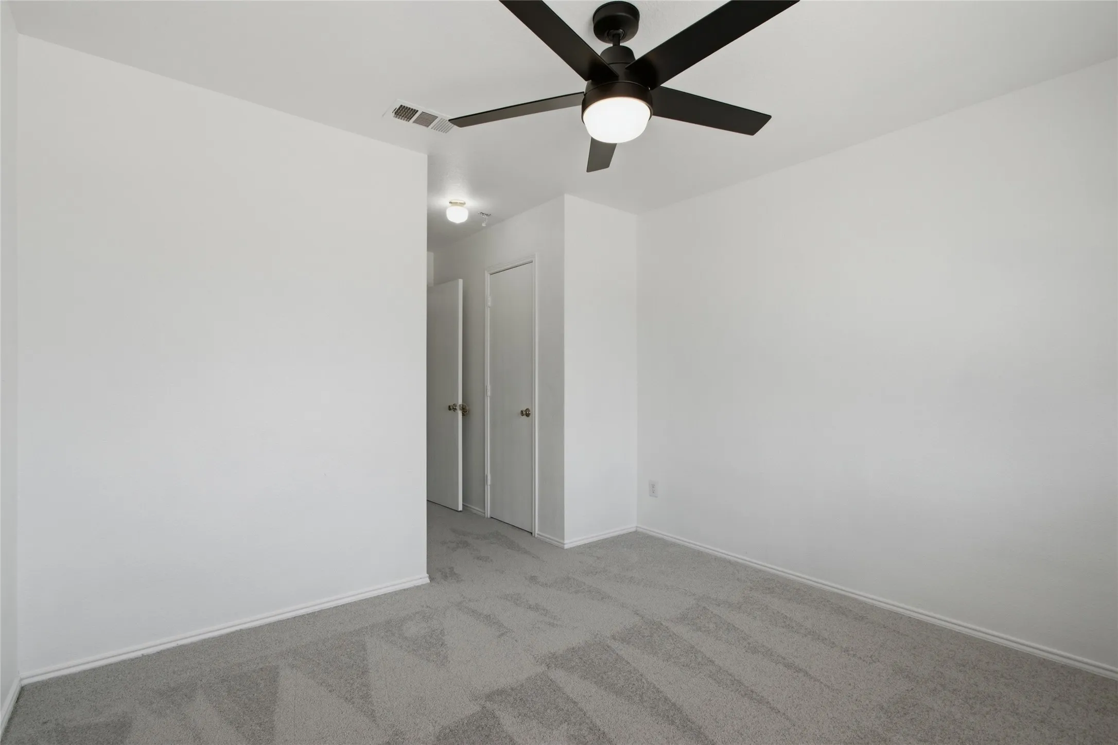 Room featuring neutral carpet flooring, white walls, a contemporary ceiling fan with integrated lighting, and white baseboards