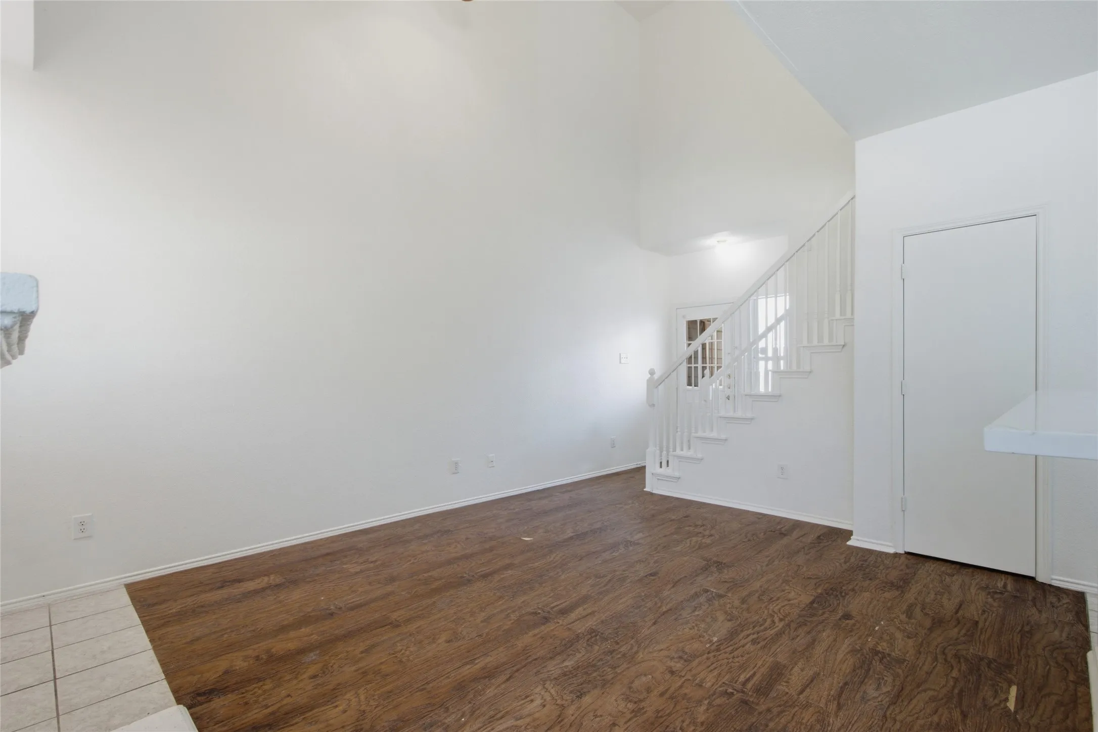 Expansive living area featuring soaring ceilings and wood-finish flooring