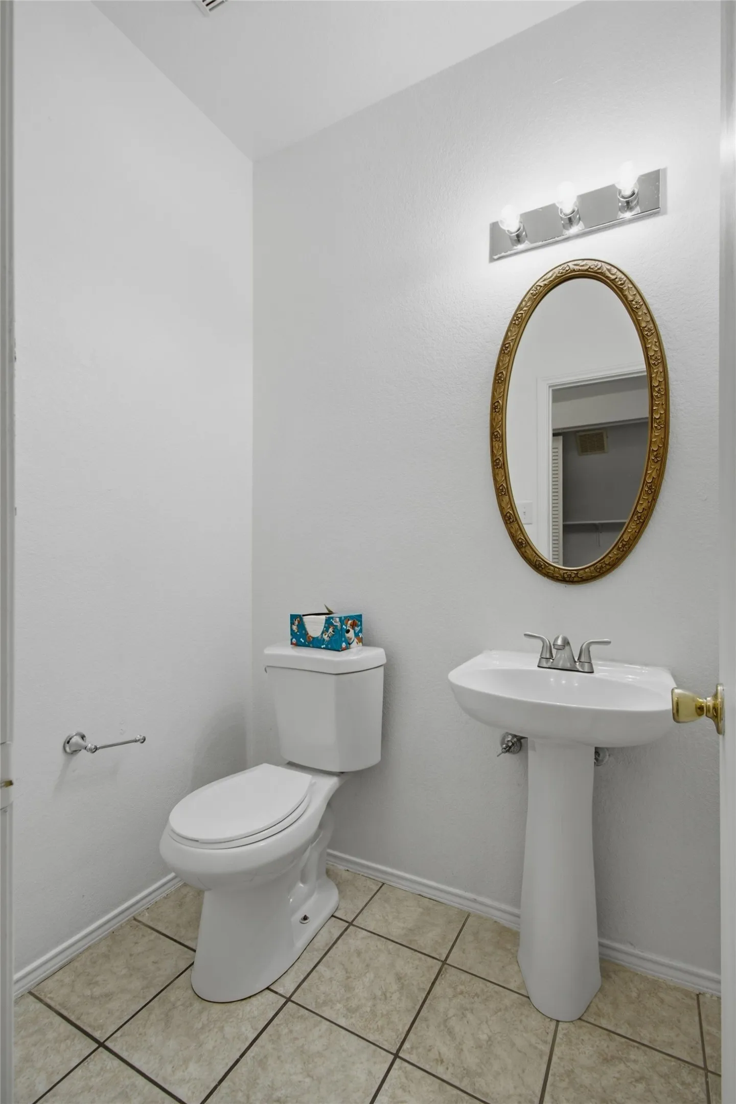 Neutral toned tile flooring complements the white walls and fixtures