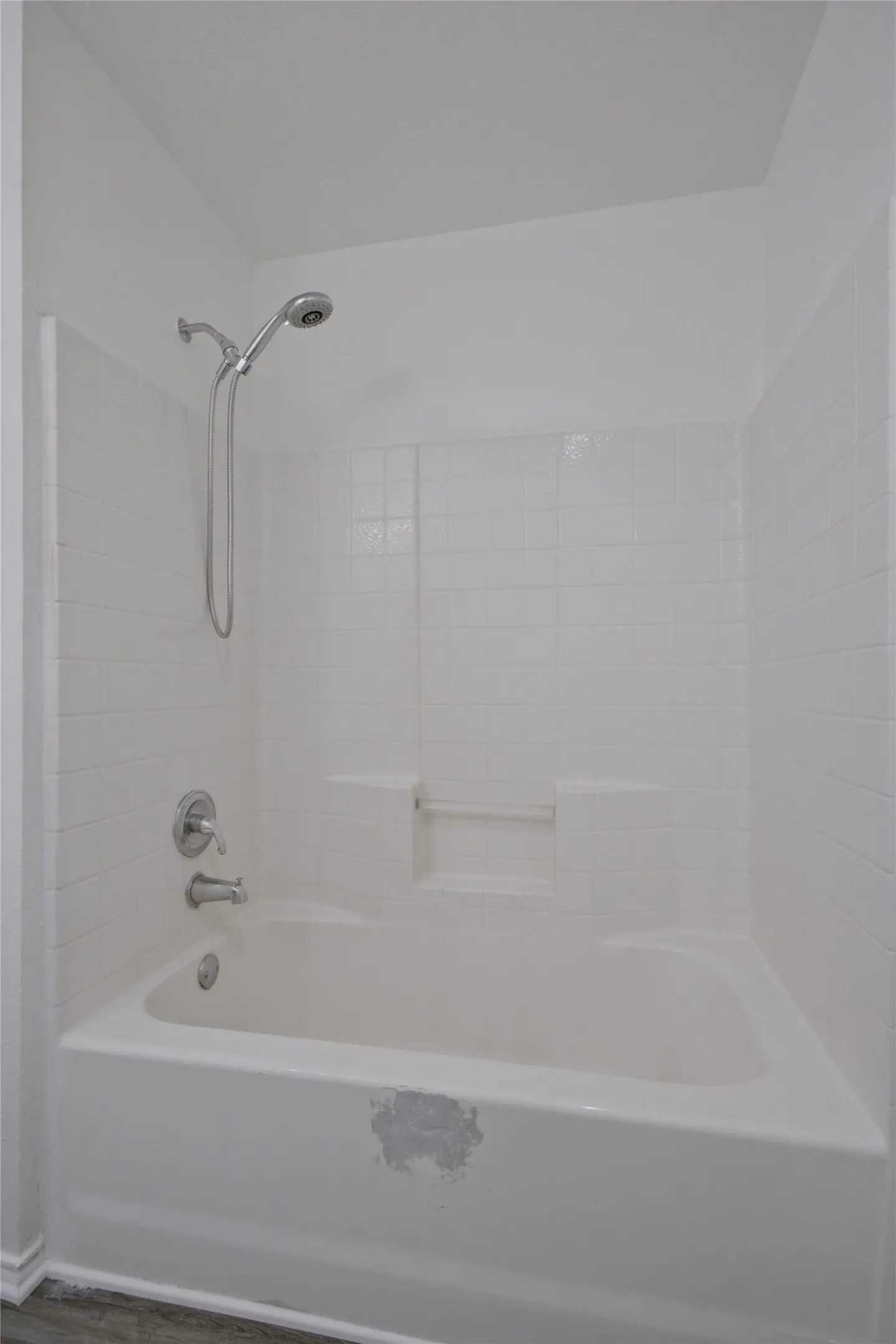 Alcove bathtub with white subway tile surround, chrome shower fixtures, and integrated soap dish