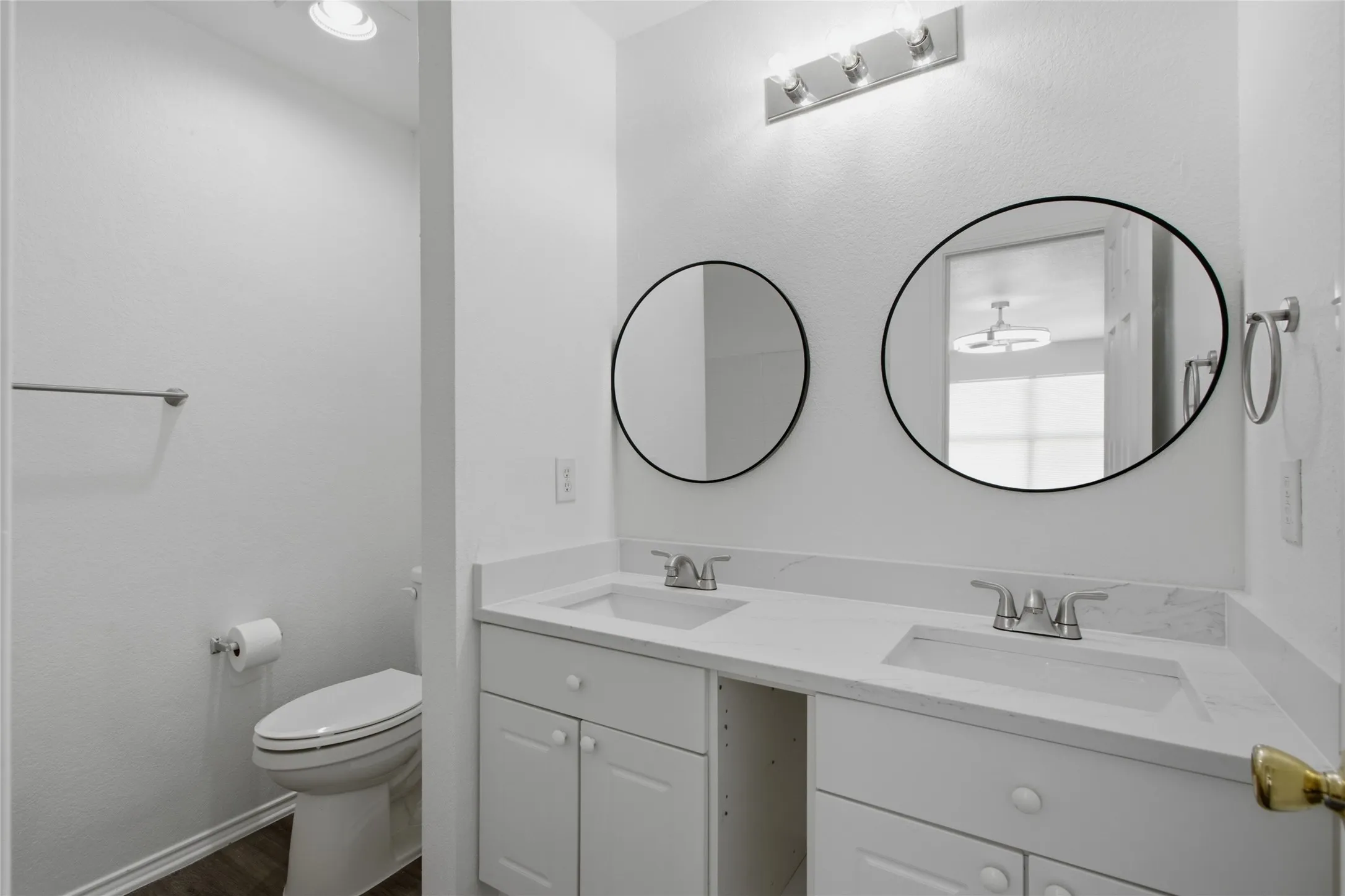 Dual vanity featuring white cabinetry and countertops with integrated sinks