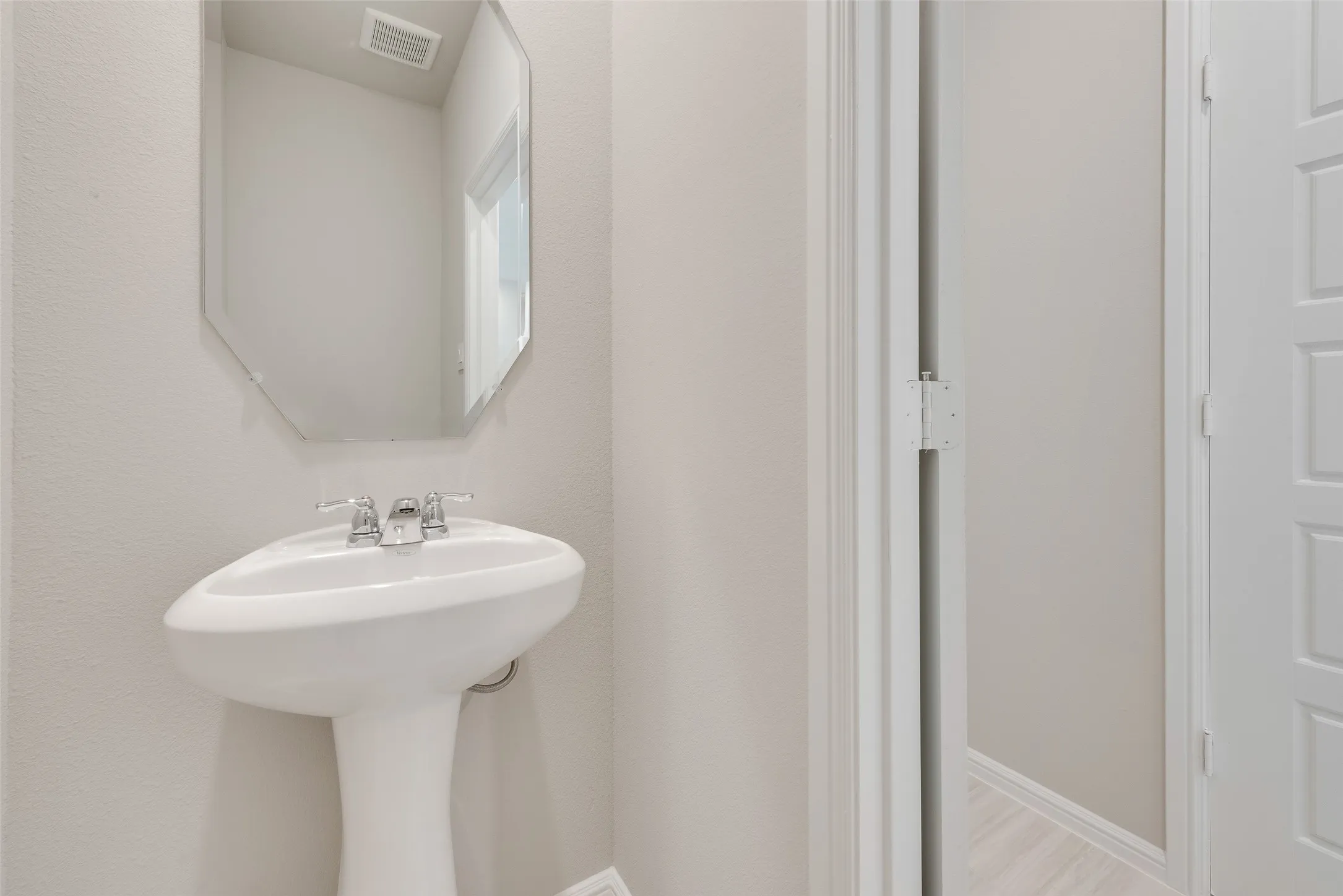 White pedestal sink with chrome faucet