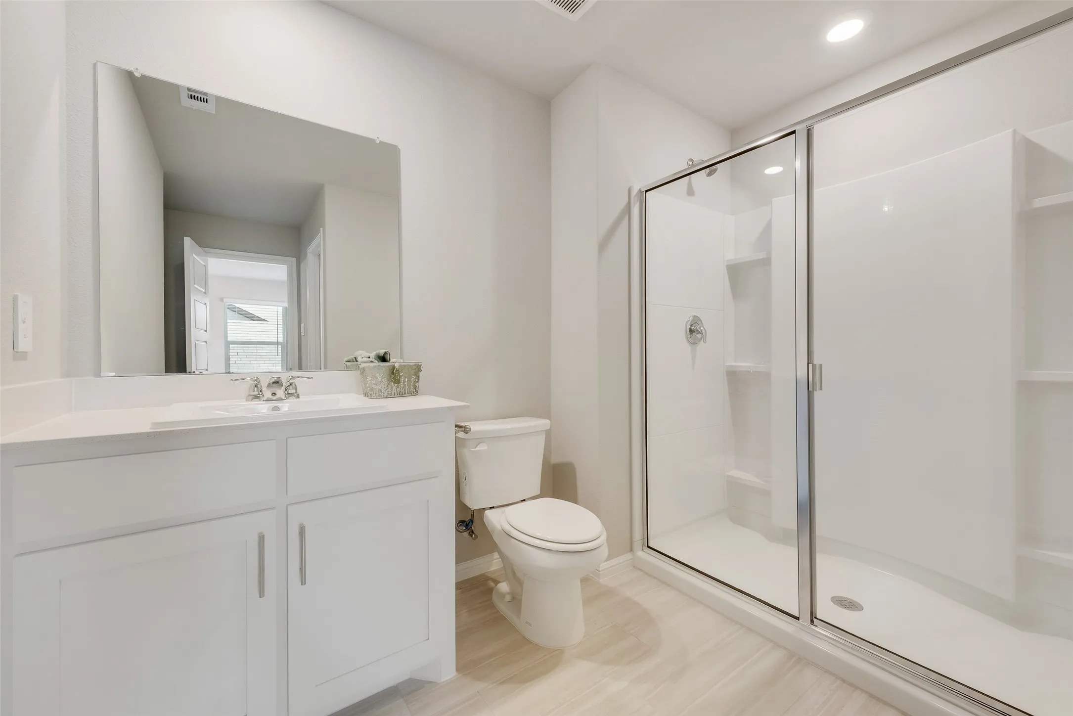 White vanity with a single basin sink, contemporary chrome faucet, and quartz countertop