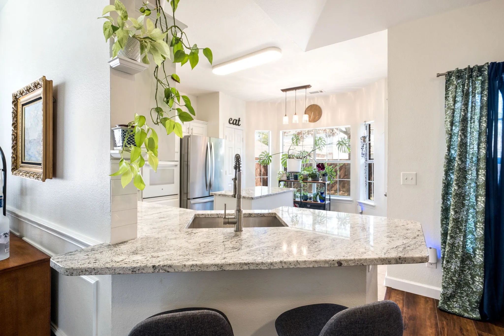 Kitchen featuring a double basin sink, light-toned countertop, and white cabinetry