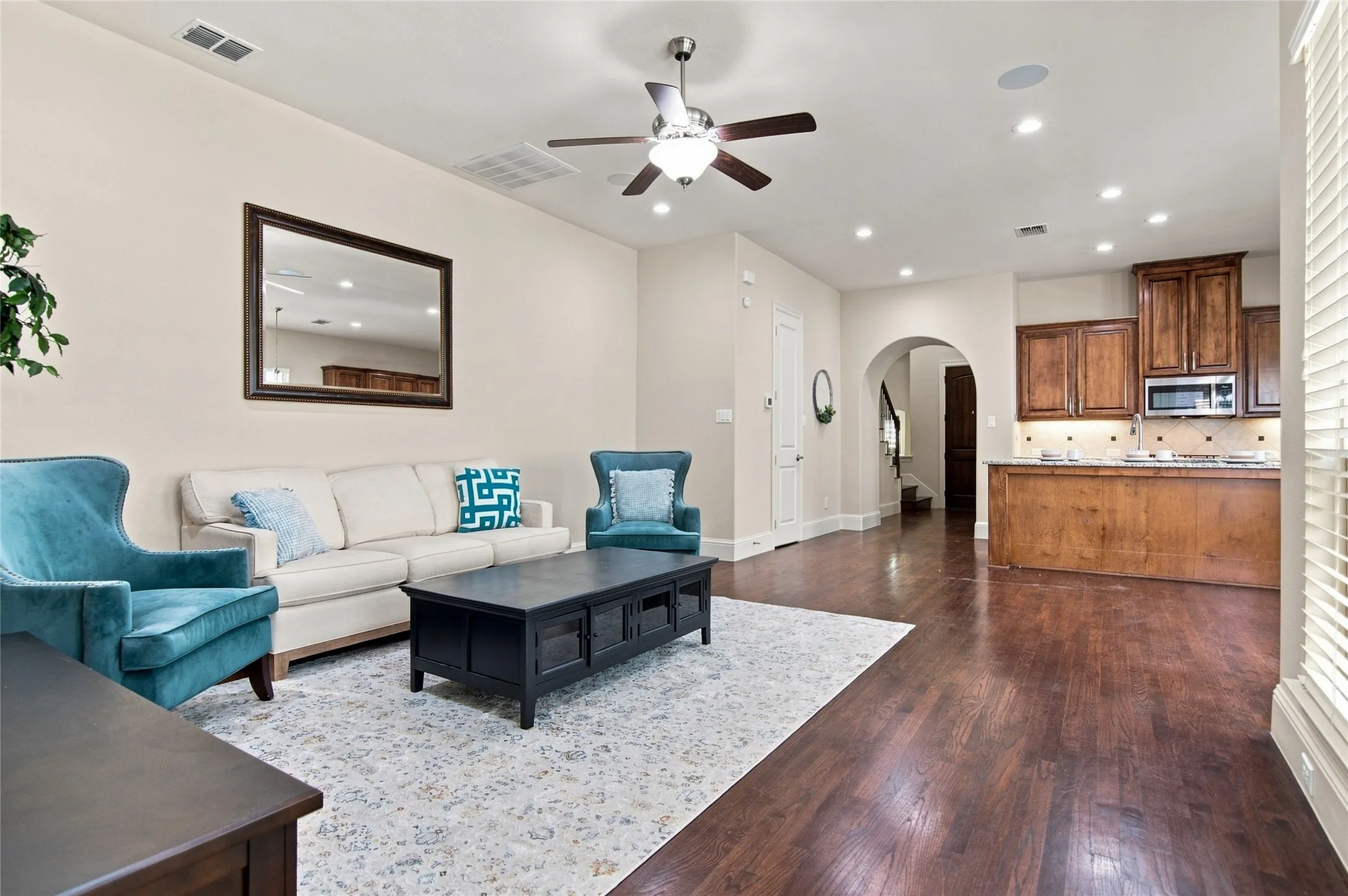 Open-concept living area featuring hardwood flooring, recessed ceiling lighting, and a ceiling fan