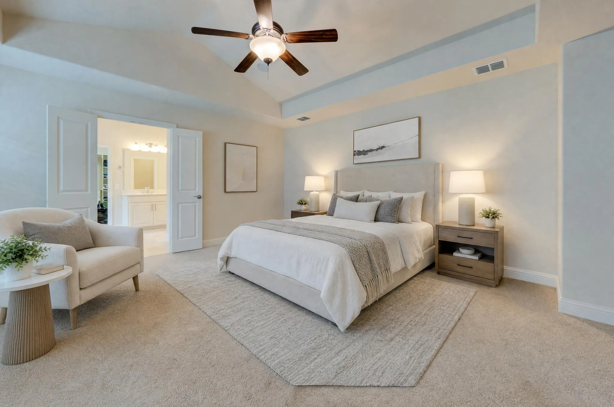 Vaulted ceiling with a ceiling fan, carpeted flooring, and a double vanity bathroom