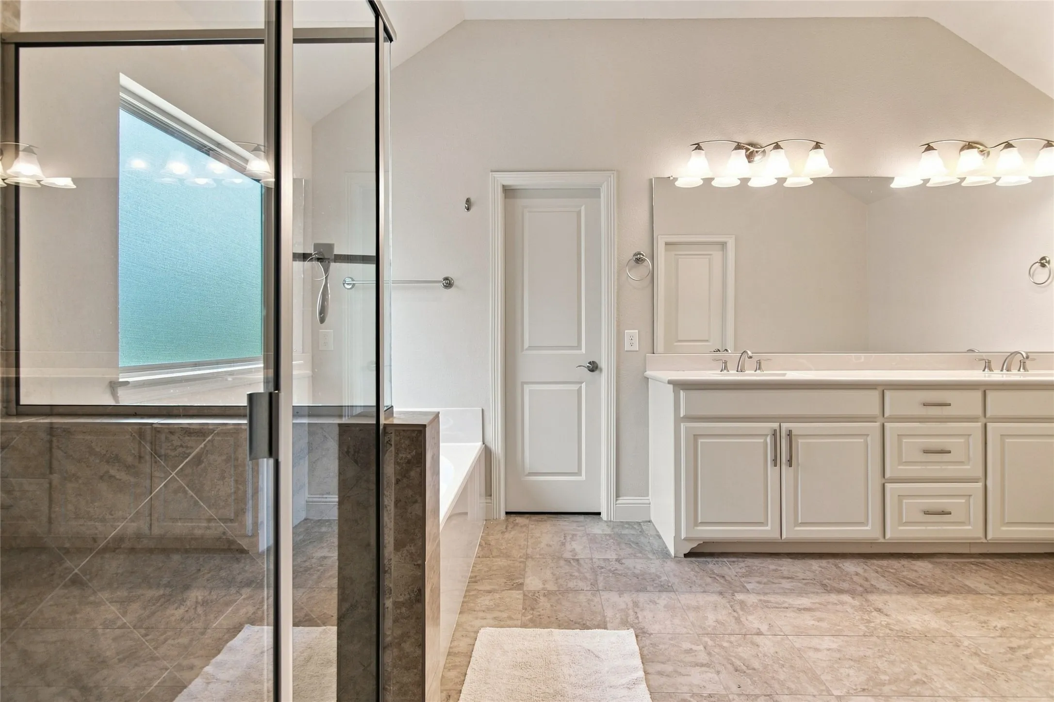 Dual vanity with white cabinetry, a large frameless mirror, and overhead lighting