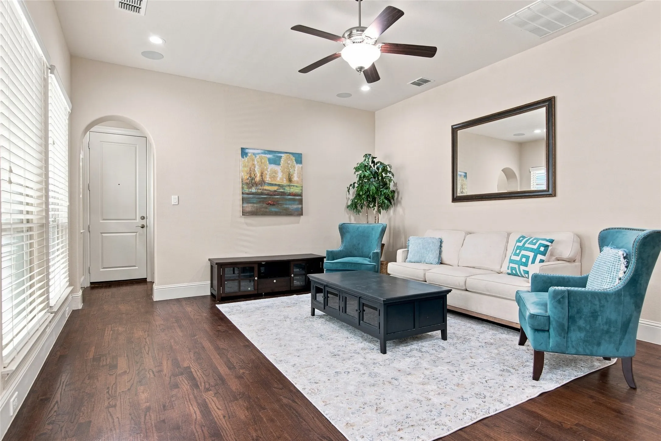 Vaulted ceiling with a ceiling fan, recessed lighting, wood-finish flooring, and arched doorway