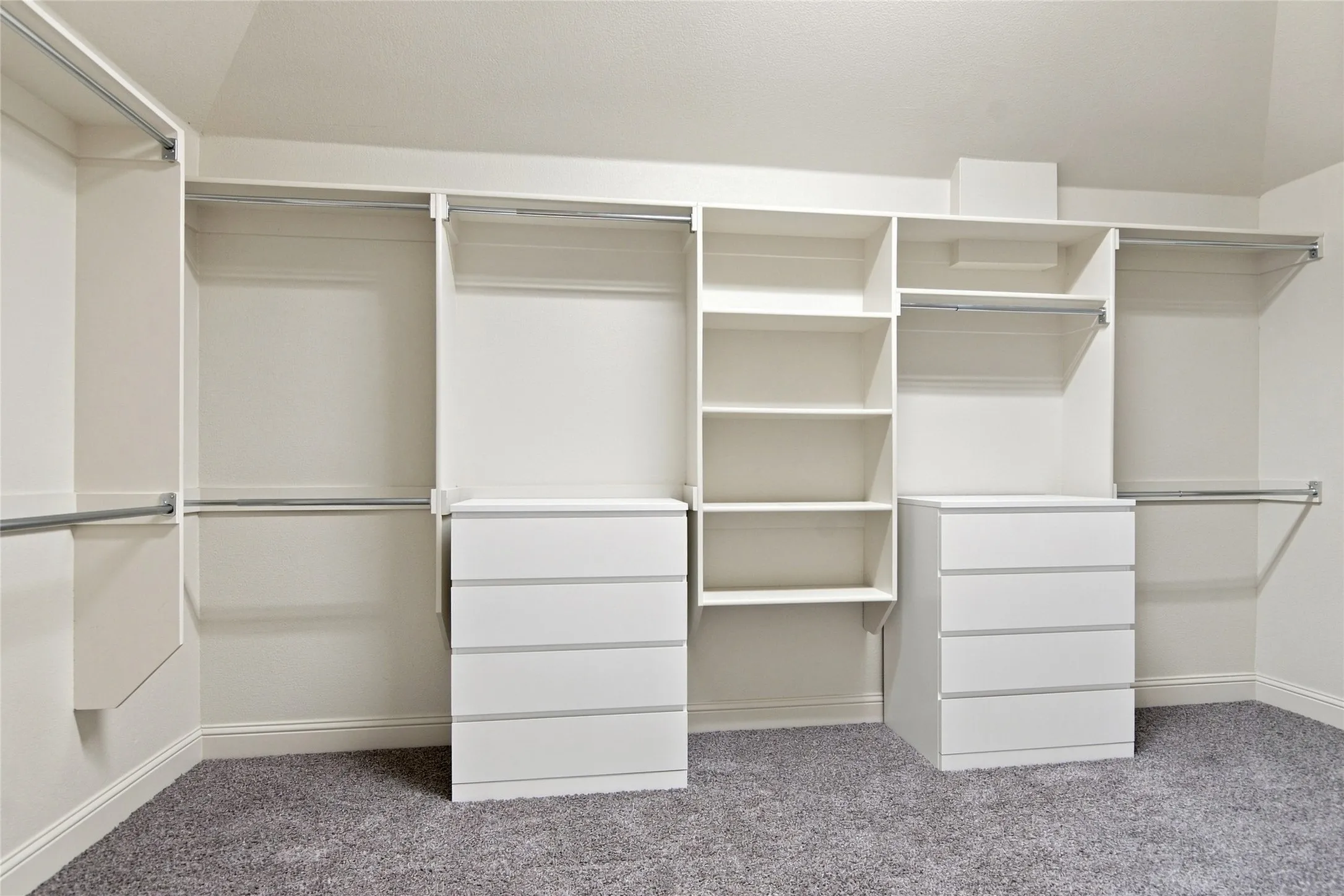 Built-in closet system featuring multiple hanging rods, integrated shelving, and drawer storage
