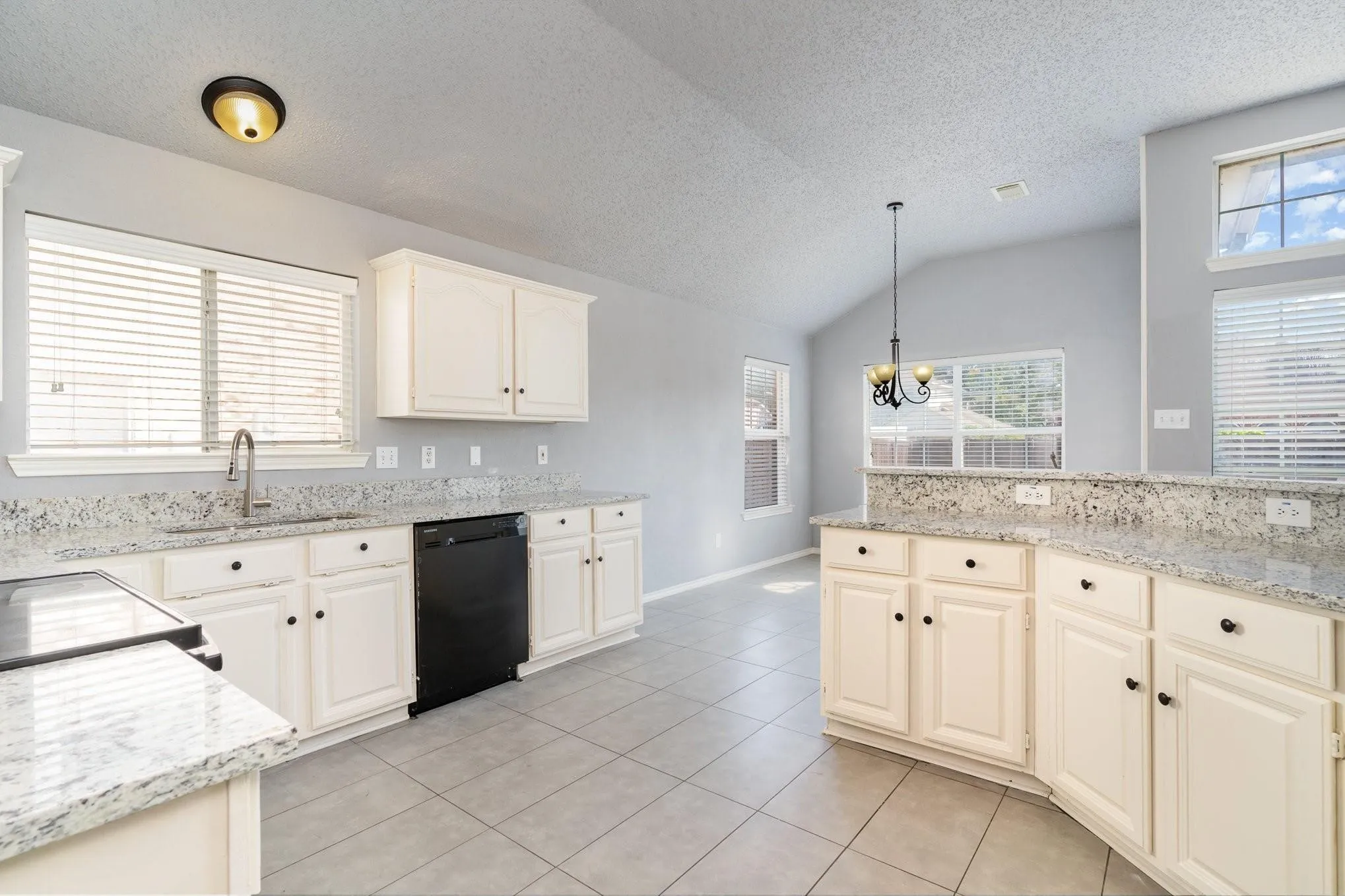 Kitchen with white cabinetry, light-toned countertops, and tile flooring