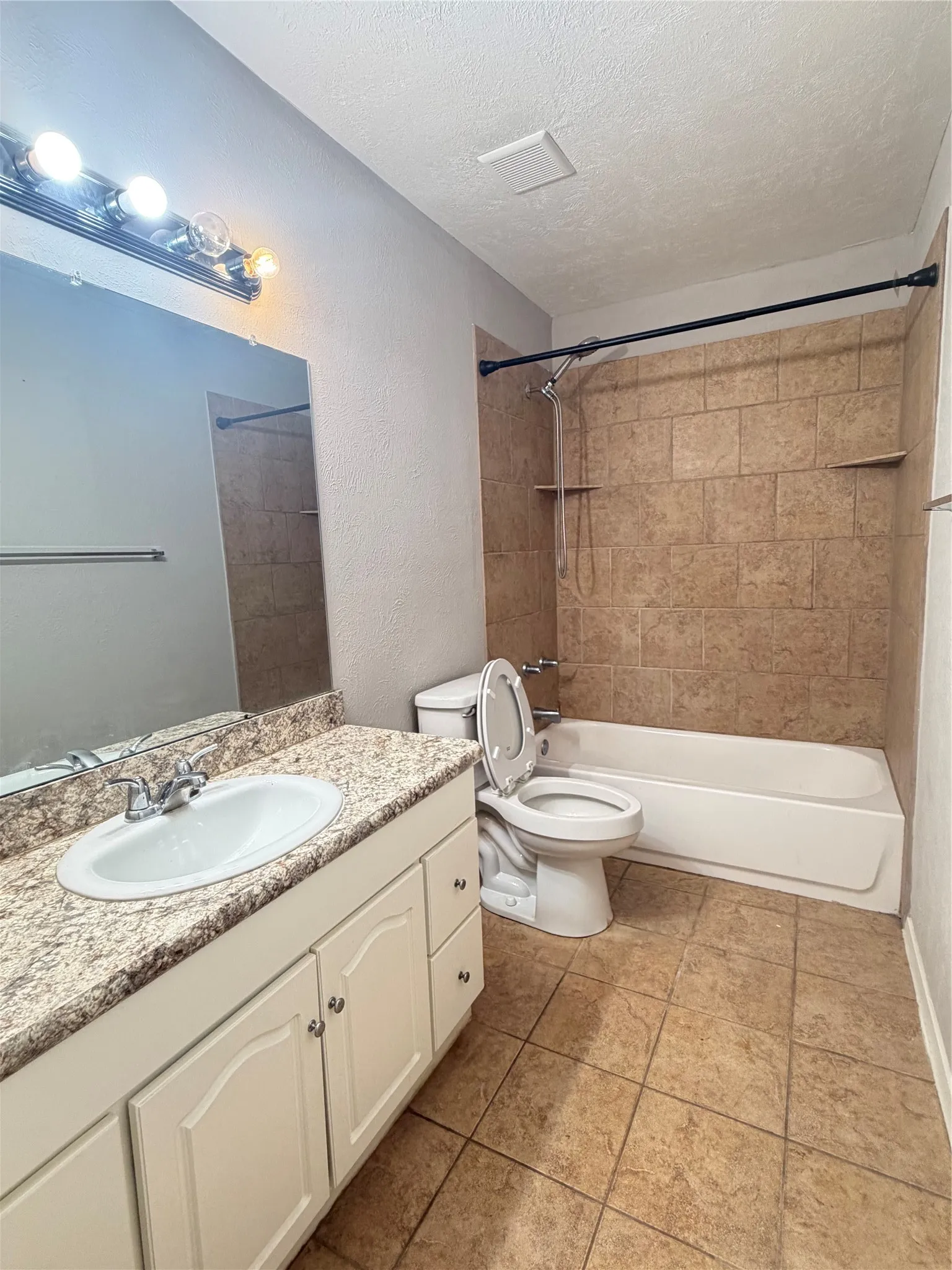 Vanity with a granite-style countertop, undermount sink, and white cabinetry