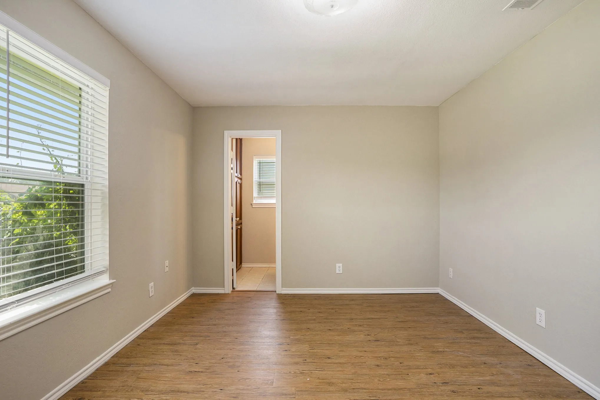 Wood-finish flooring with neutral wall tones and white trim