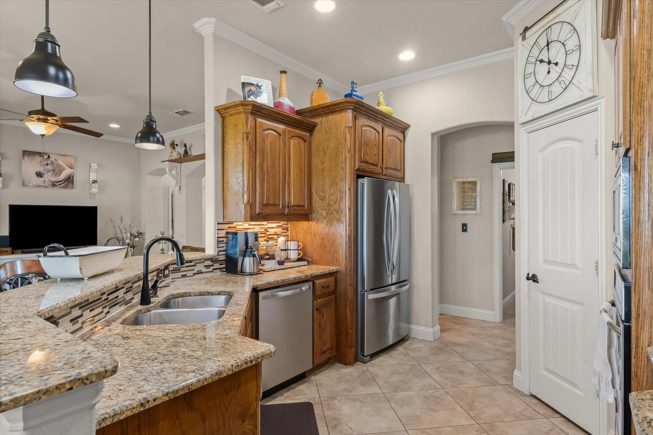 Granite countertops, stainless steel appliances, wood cabinetry, tile flooring, and a decorative tile backsplash