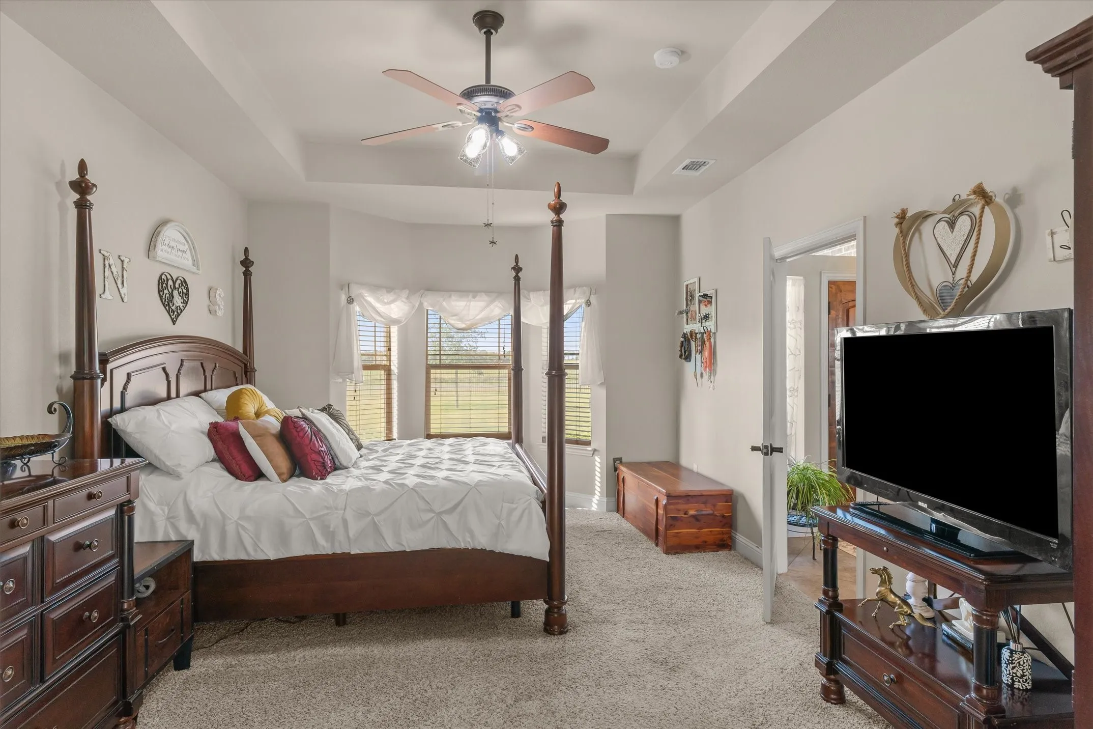 Tray ceiling featuring a ceiling fan